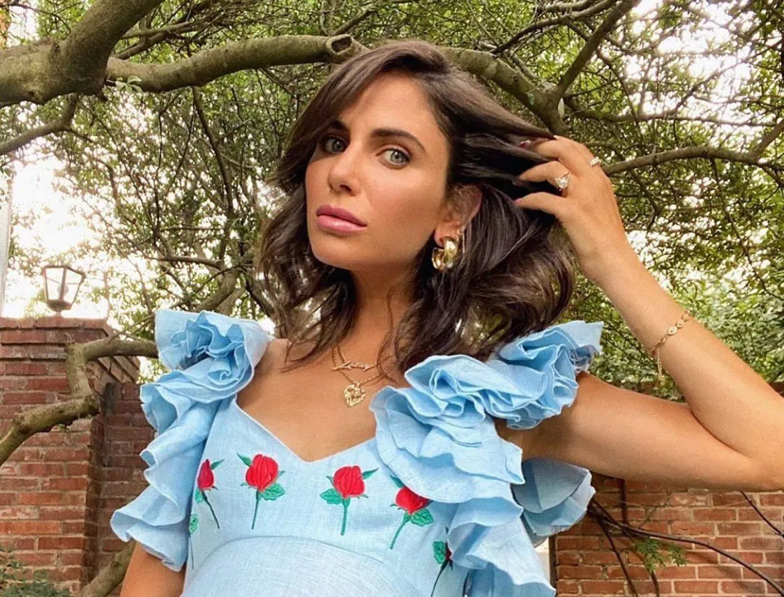Woman in a light blue floral dress showcasing elegant gold hoop earrings