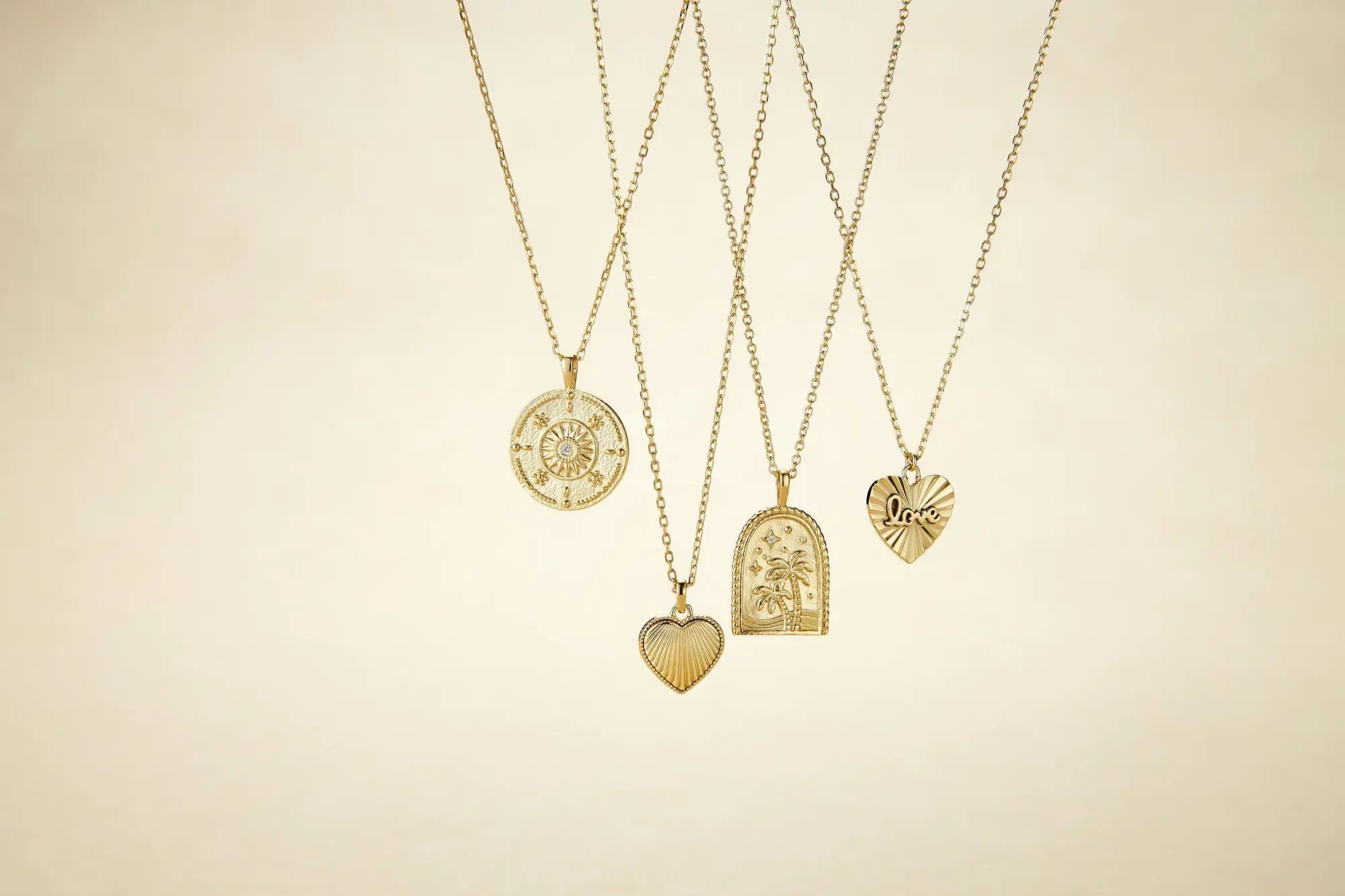 Gold pendant necklaces from Demi-Fine Jewelry collection displayed elegantly