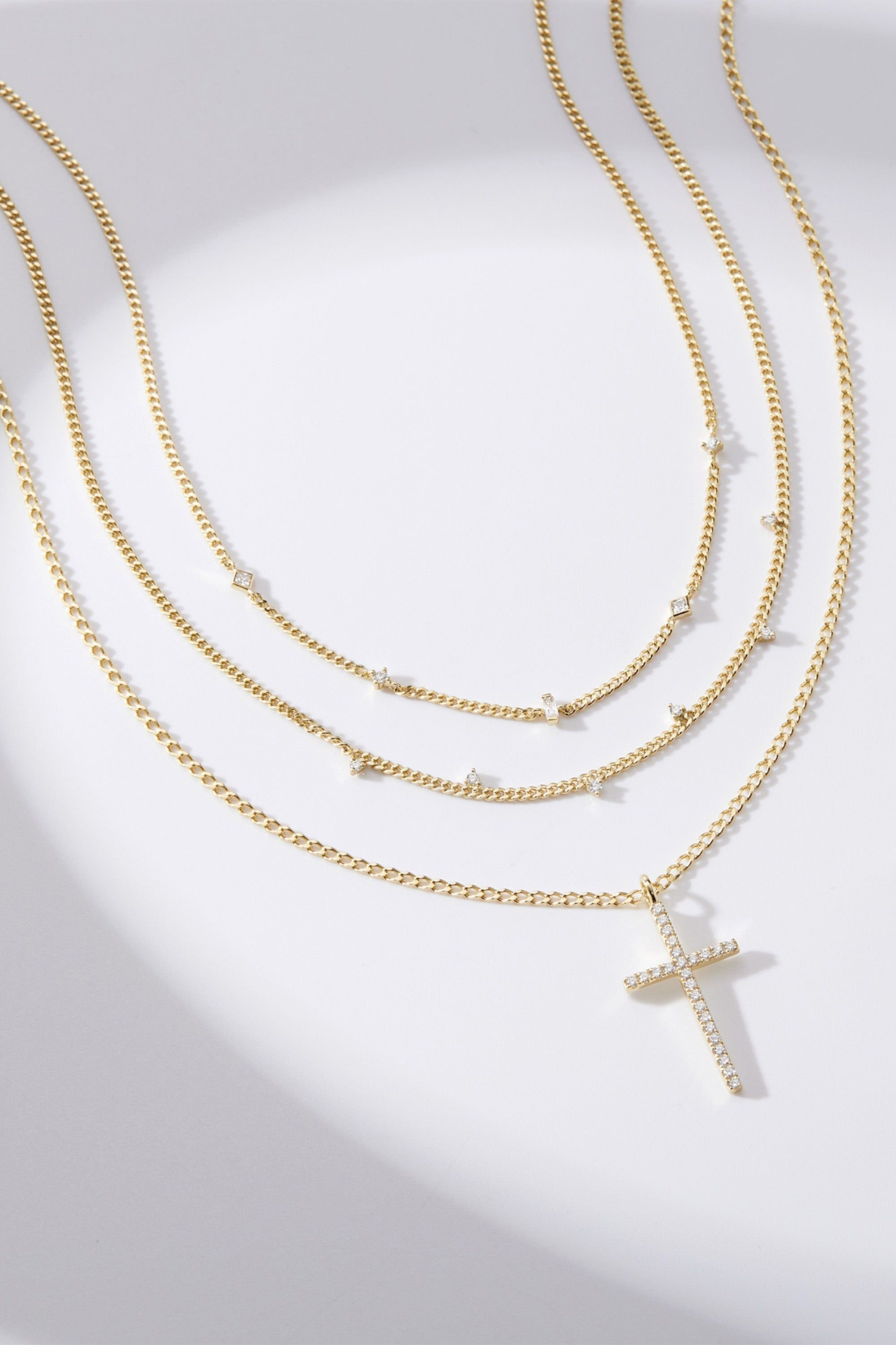 Layered gold chain necklaces with sparkling accents and a pavé cross pendant for CZ Cross Pendant Necklace