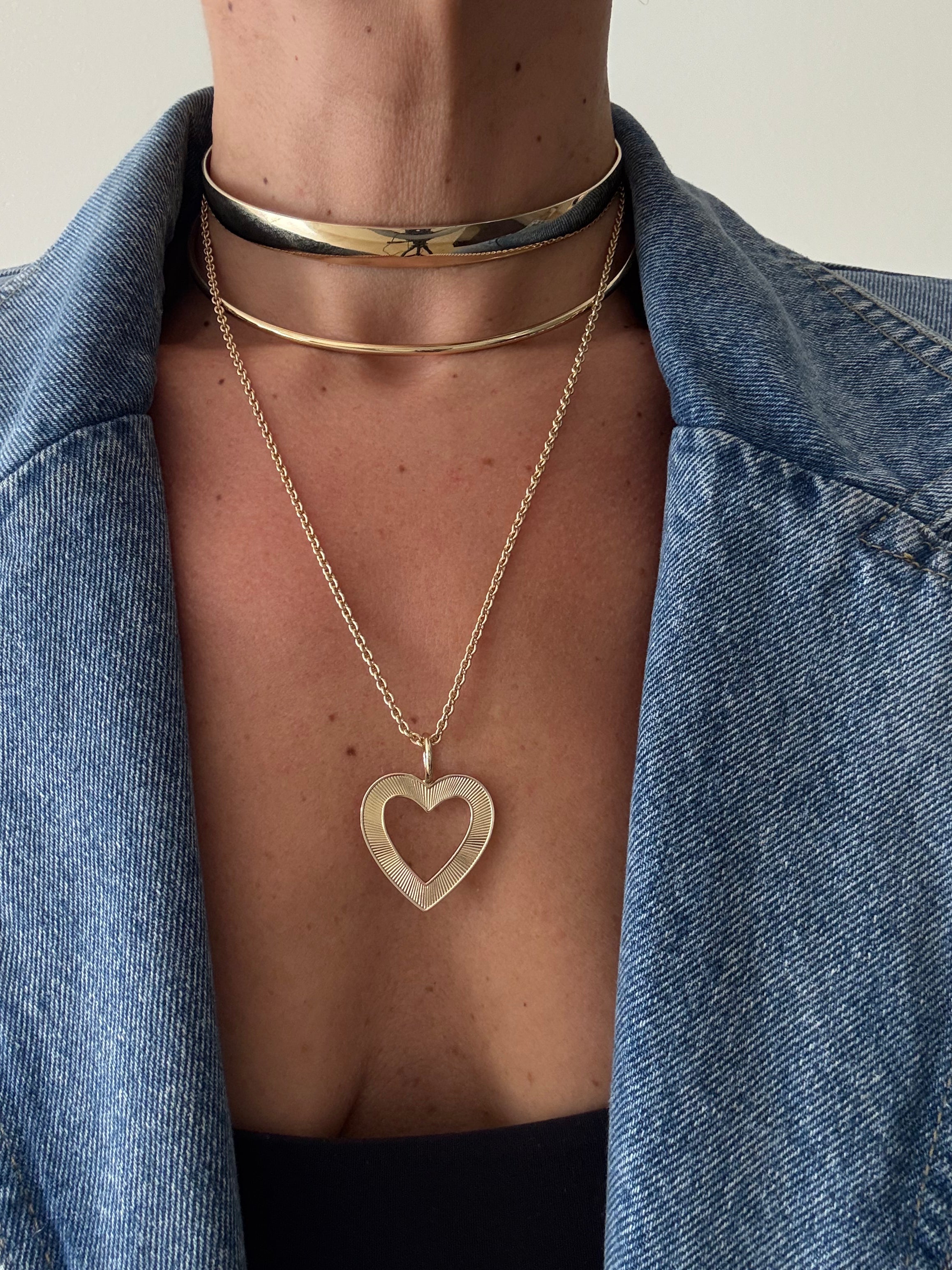 Person wearing Hannah Open Heart Pendant layered gold necklaces with choker, delicate, and long chain