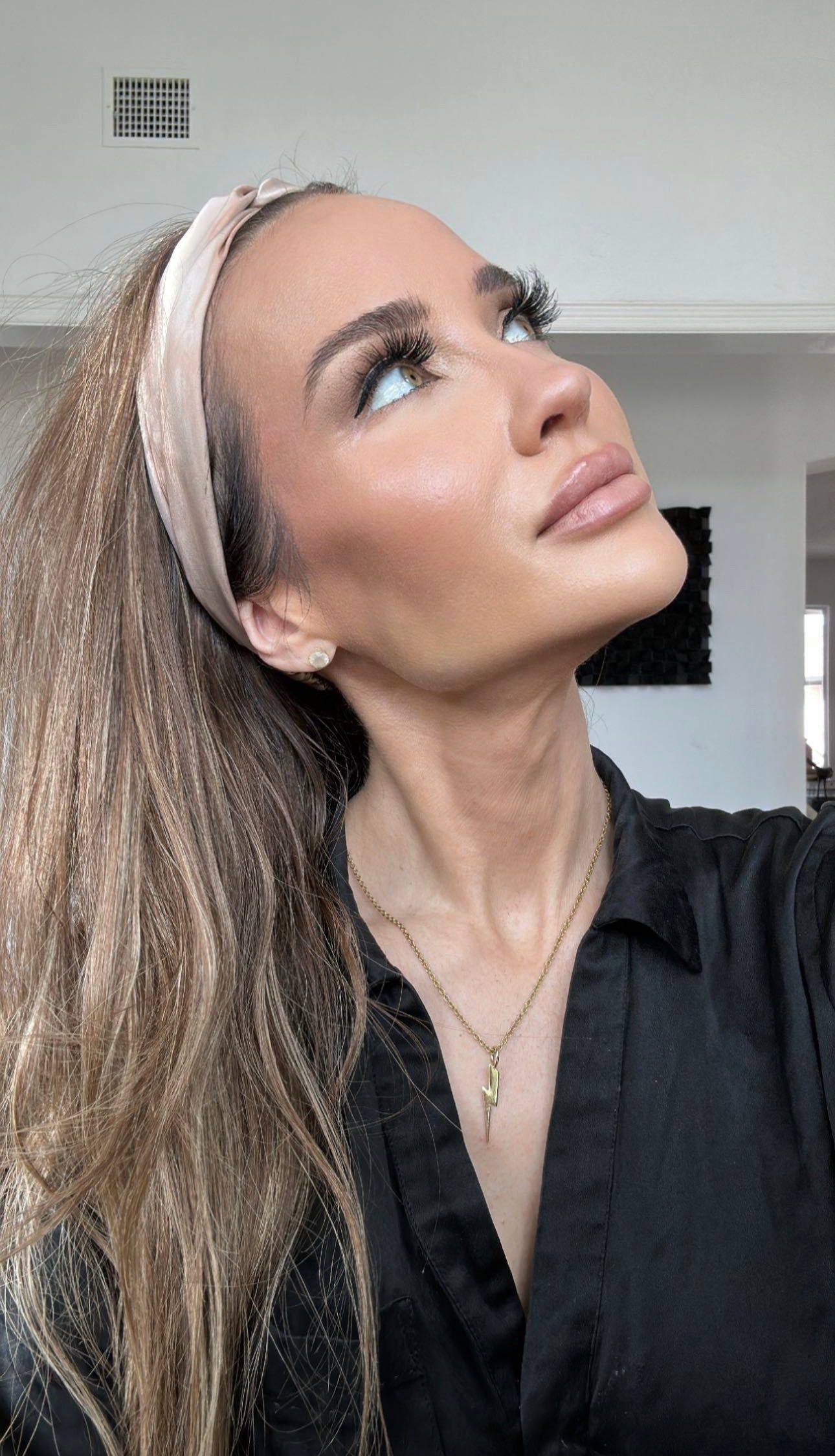 Woman with long brown hair wearing a Katie Necklace with lightning bolt pendant