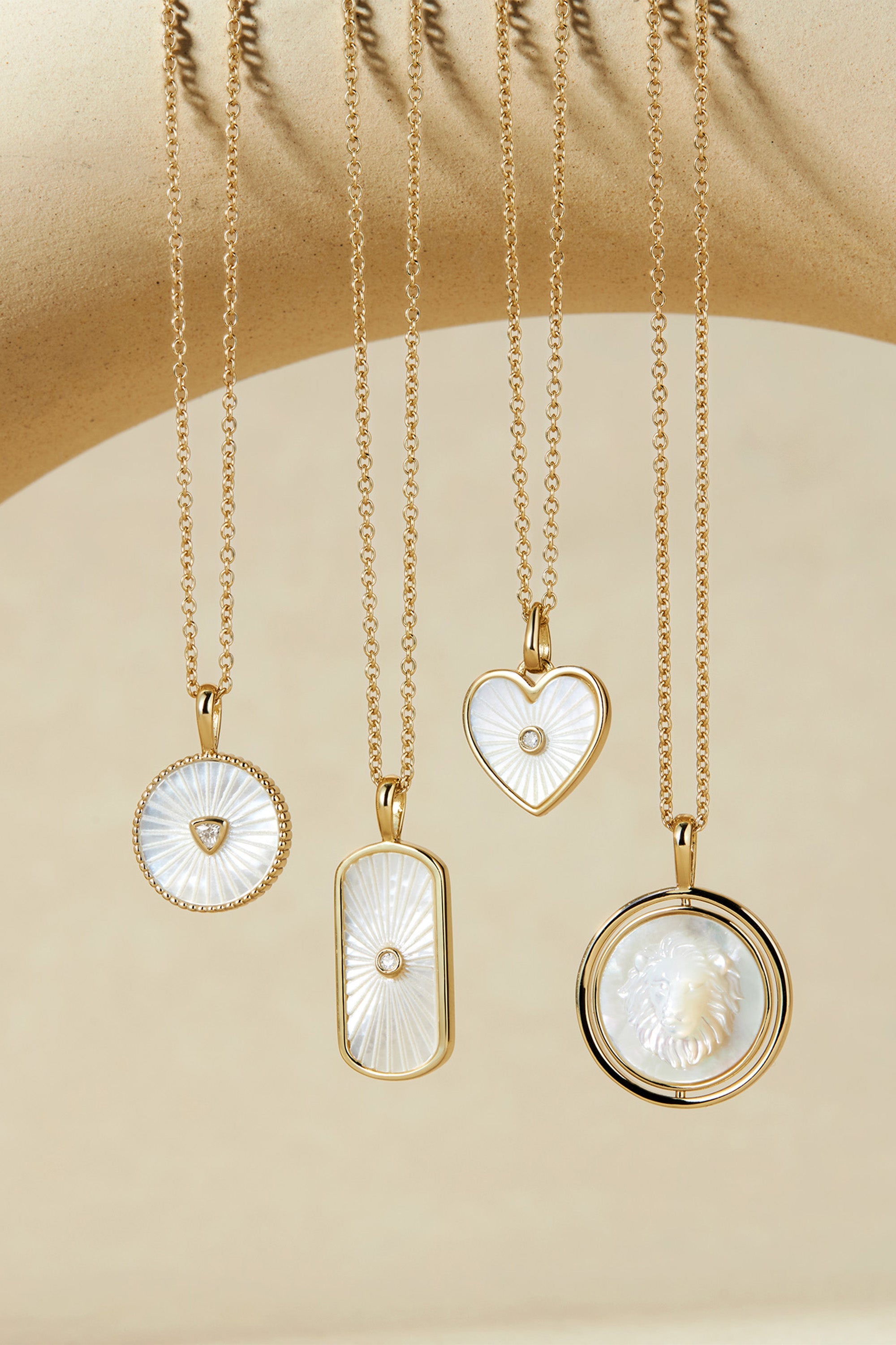 Five delicate gold chain necklaces with mother-of-pearl pendants and CZ center stone