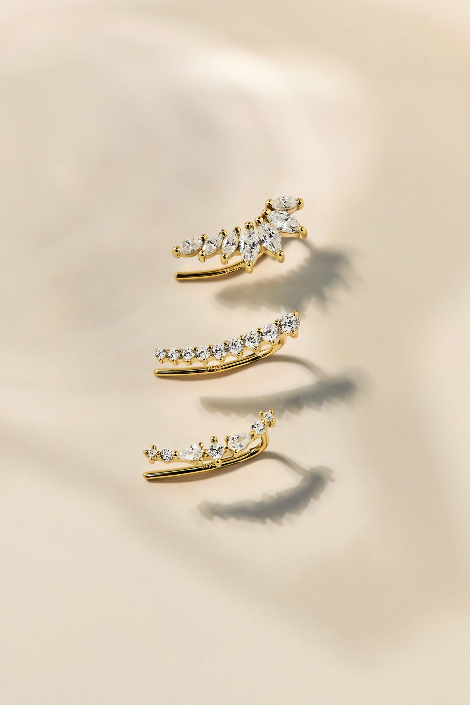 Gold-toned ear climber earrings with sparkling cubic zirconia stones in various arrangements