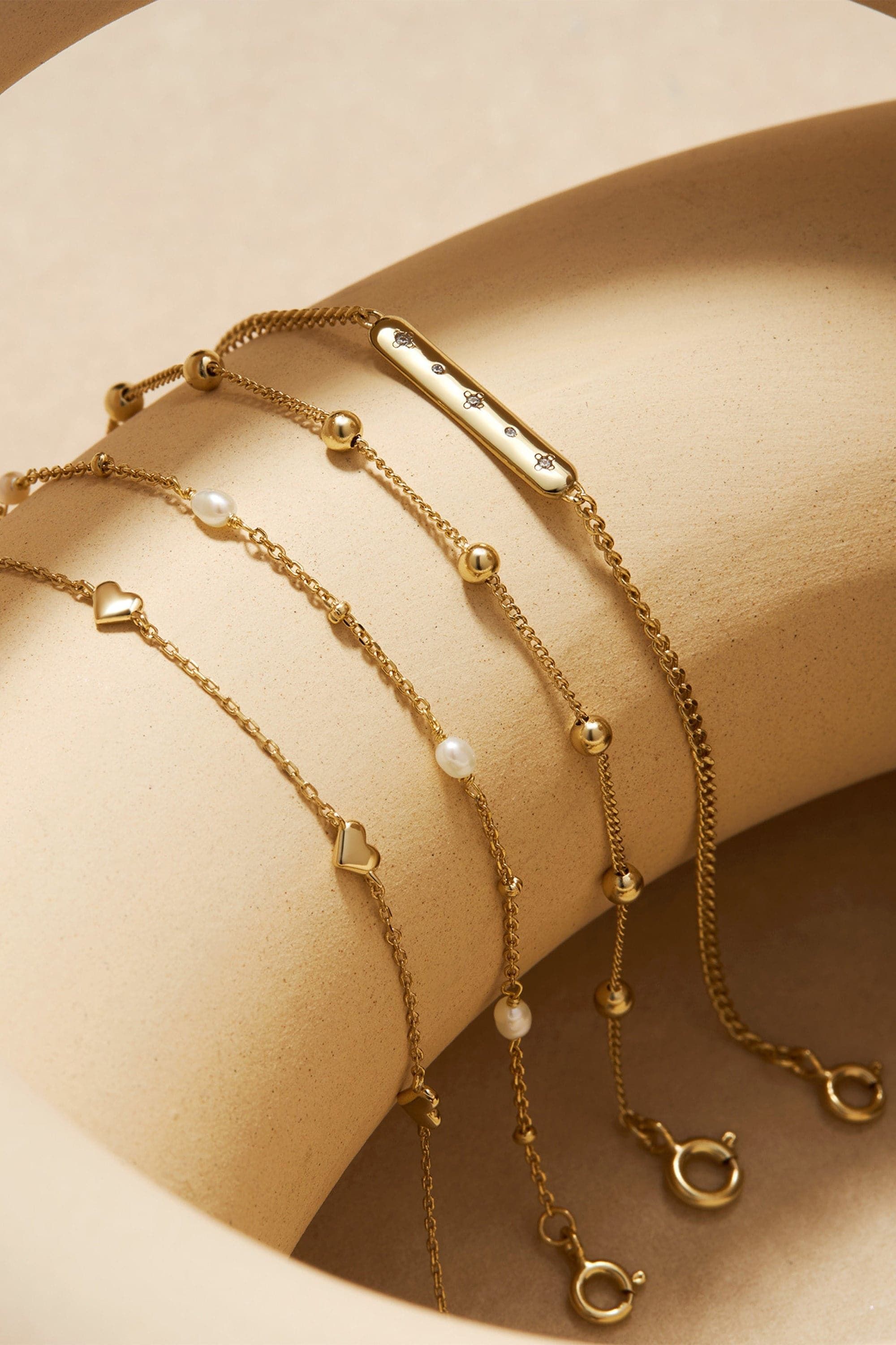 Delicate gold chain bracelets with charms and clasps from the Micro Bead & Chain Bracelet collection