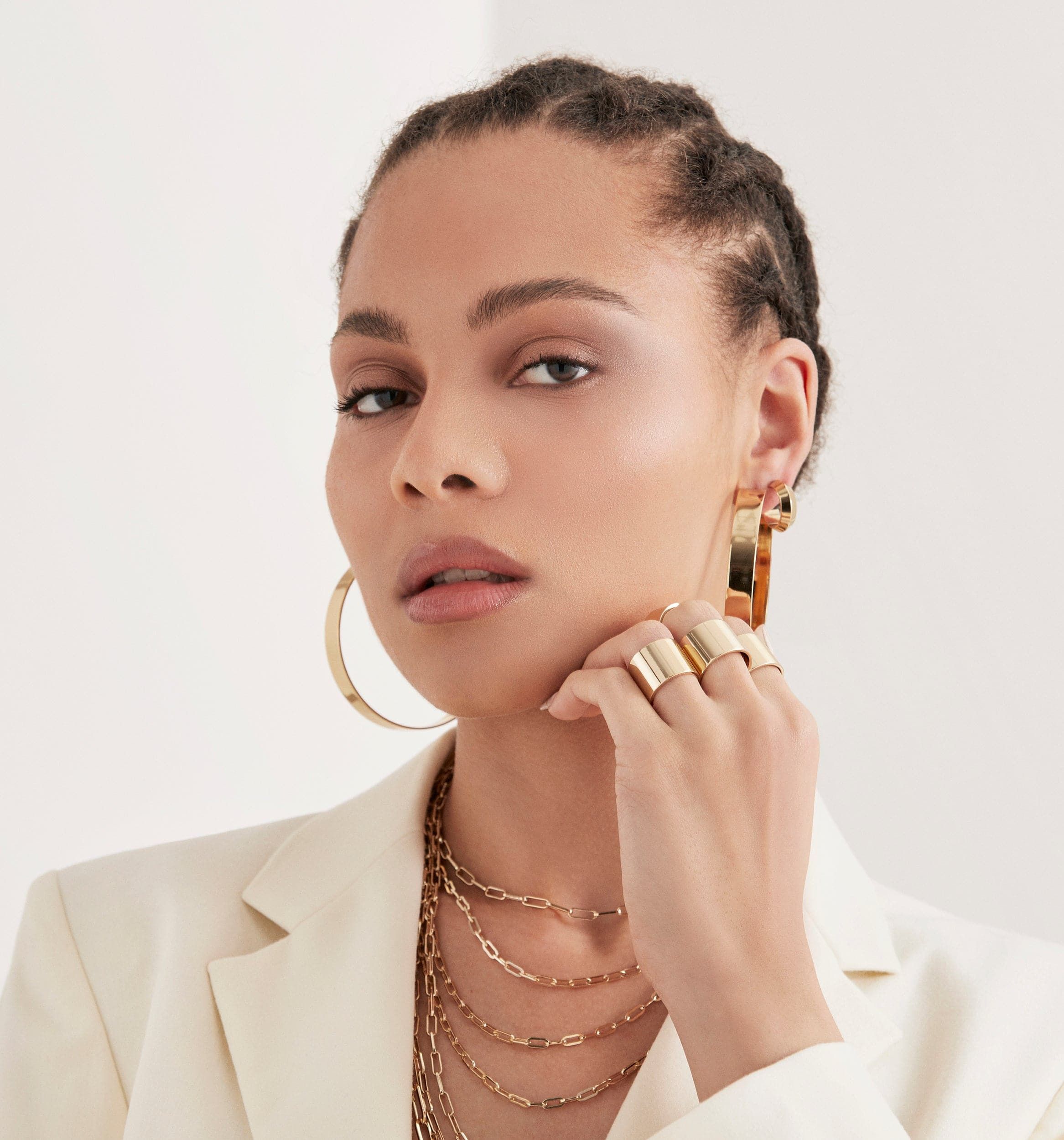 Woman wearing gold jewelry with Mini Peak Hoops earrings looking stylish and chic