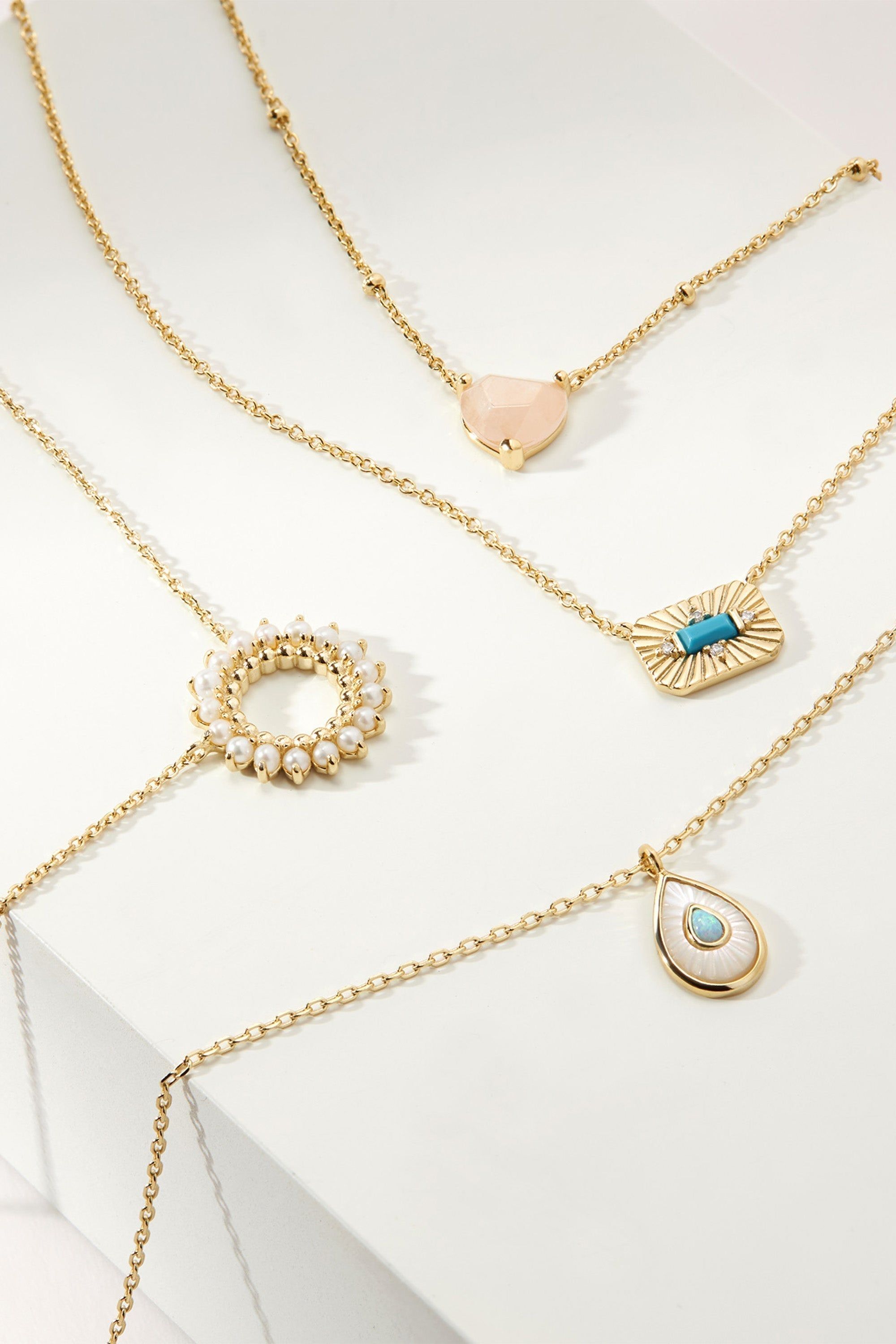 Gold necklaces with various pendants, including the Open Center Multi Pearl Pendant Necklace