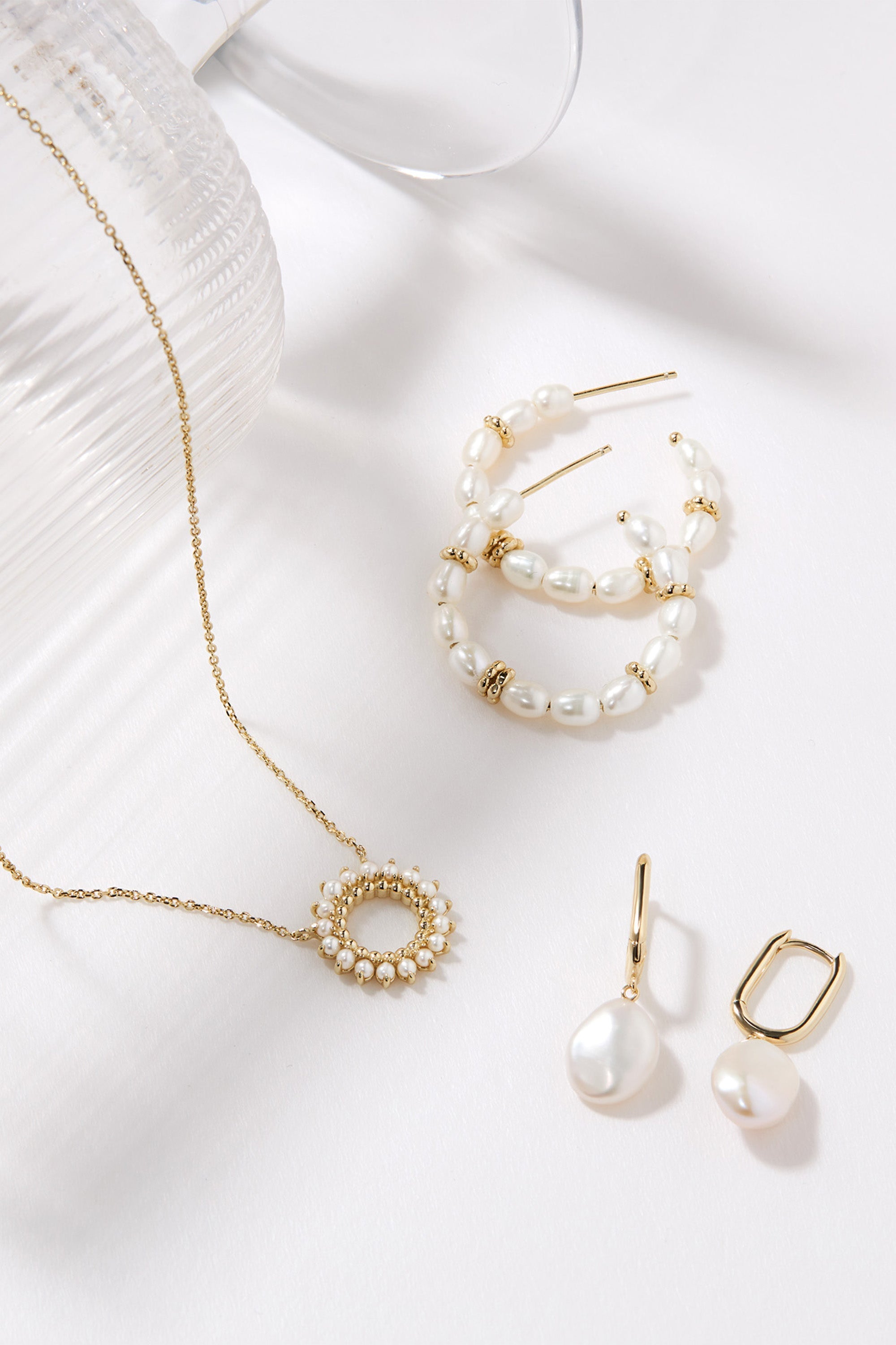 Pearl and gold jewelry set featuring Oval Huggie Hoops with Pearl Drop Earrings