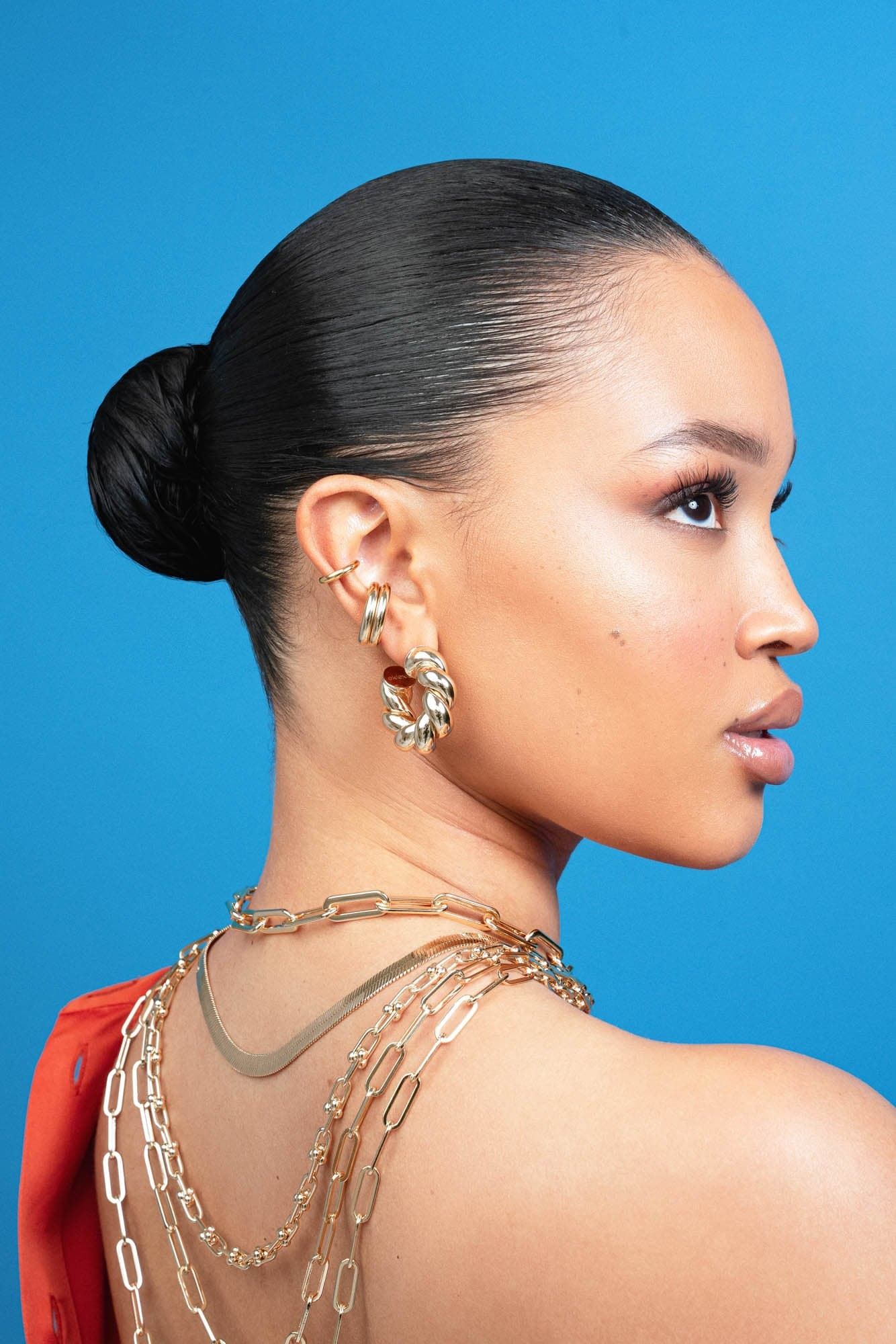 Woman with slicked-back hair and gold Tallulah Hoops jewelry