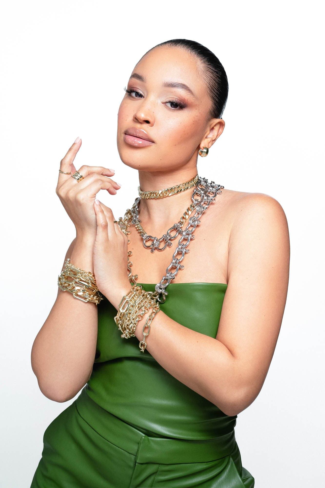 Woman in green outfit wearing Two Toned Hendrick Necklace and jewelry piece