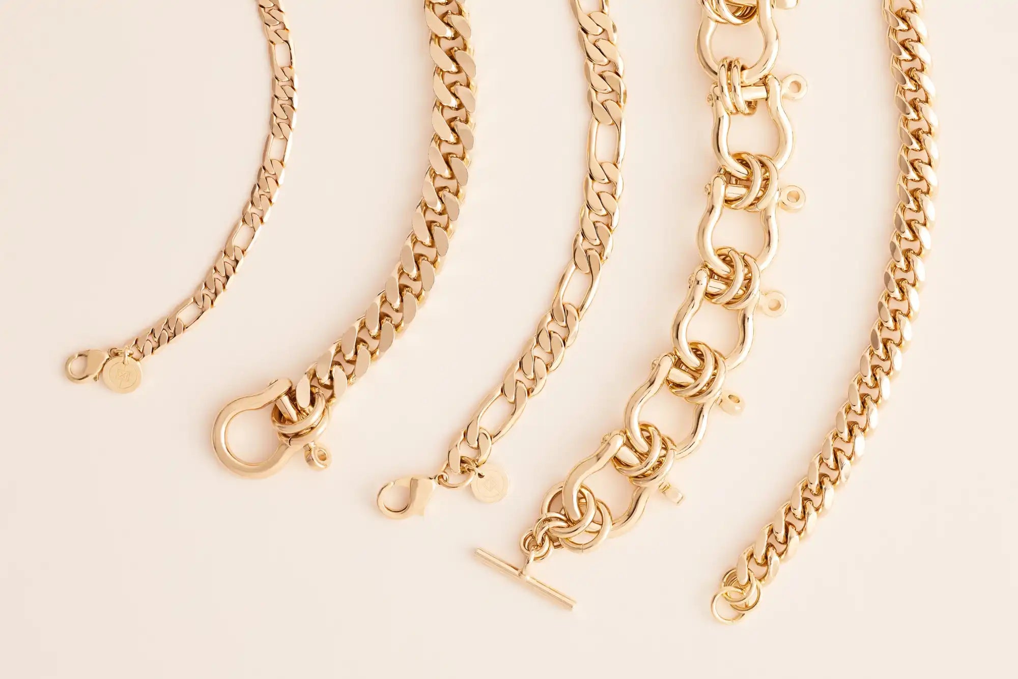 Gold chain necklaces on a light beige background