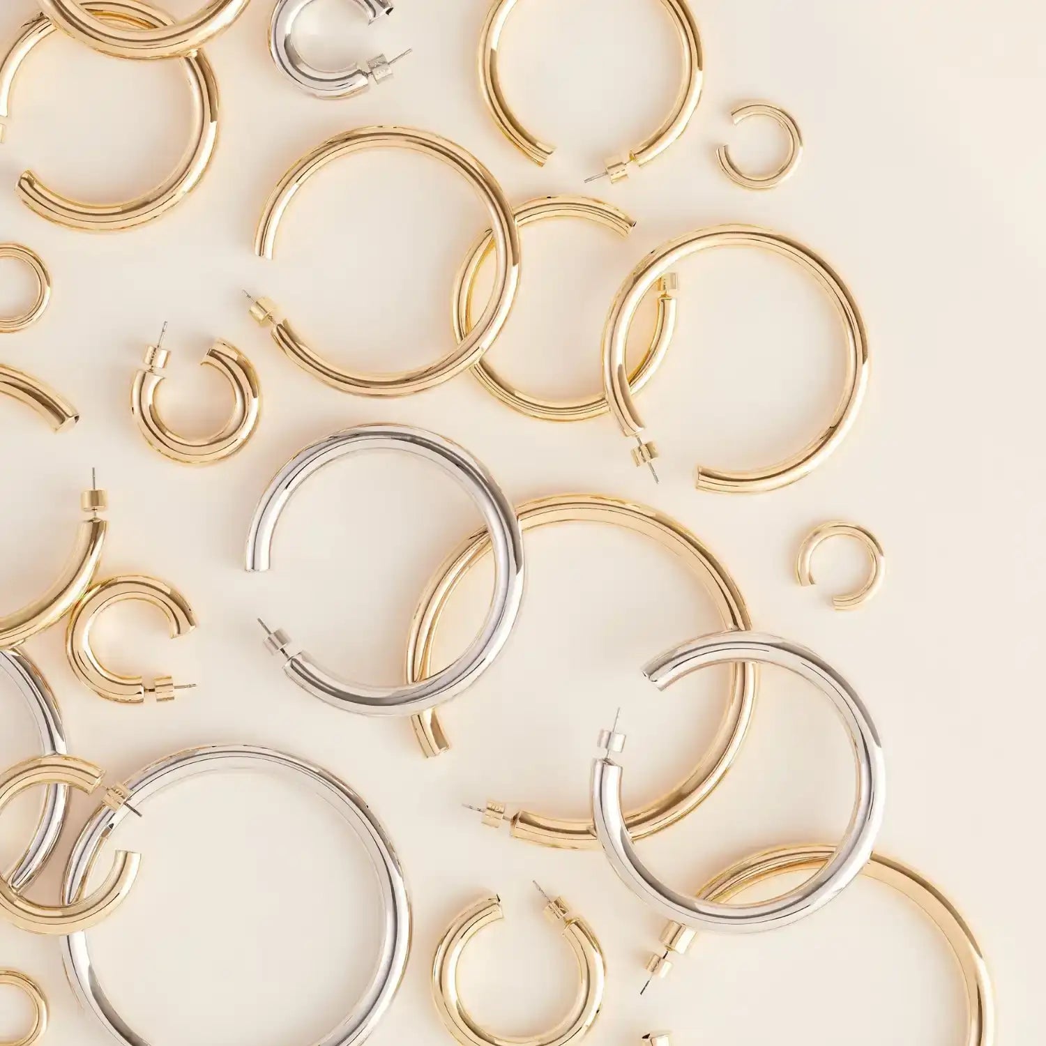 A collection of gold and silver hoop earrings in various sizes.