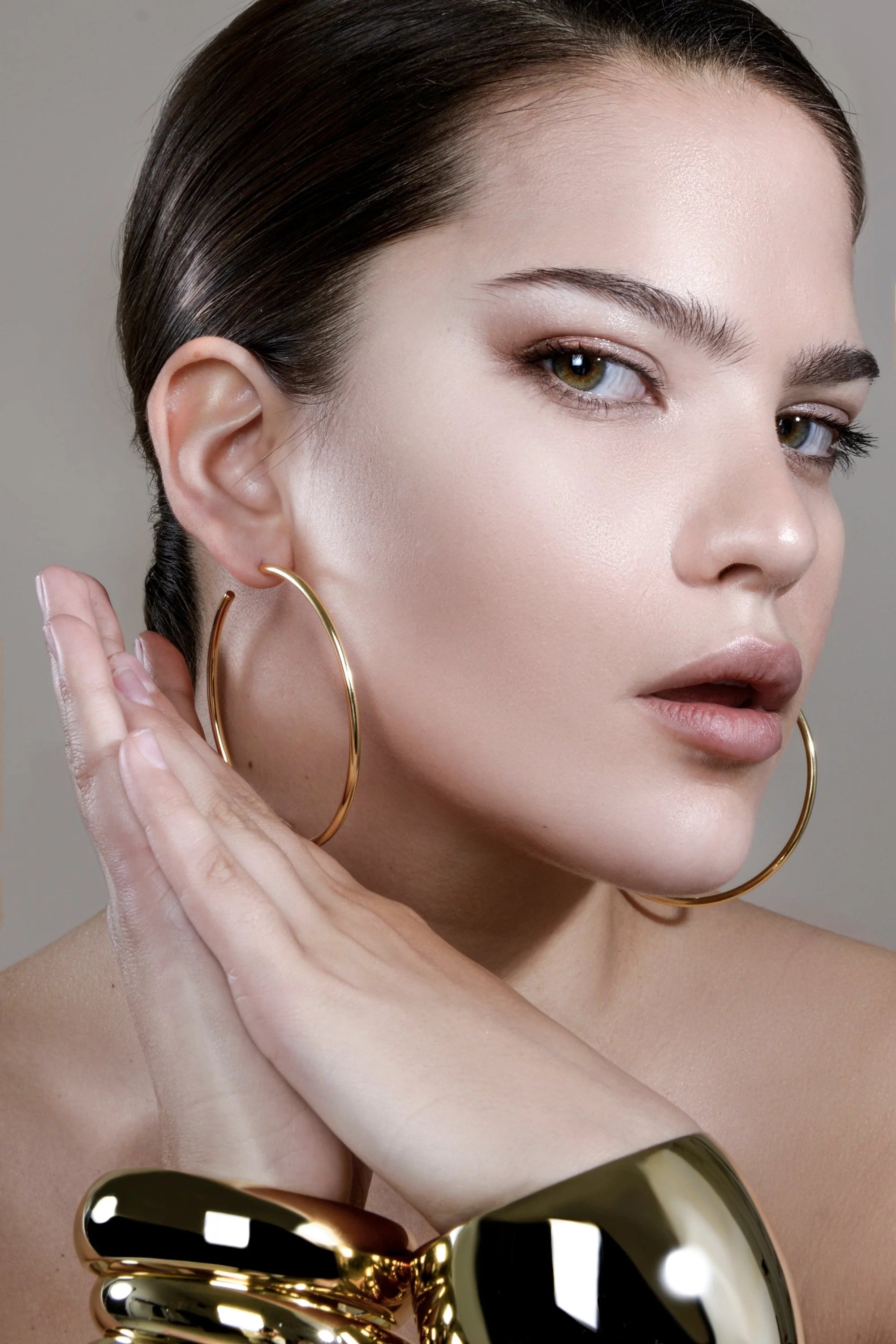 Woman showing off the stunning 2.5 inch Ultimate Hoops gold jewelry