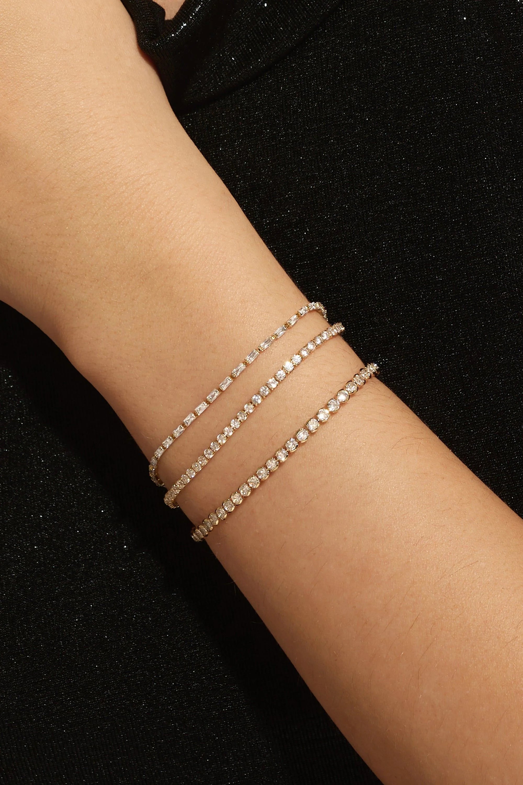 Shiny Baguette CZ Tennis Bracelet with three delicate sparkling bracelets on display