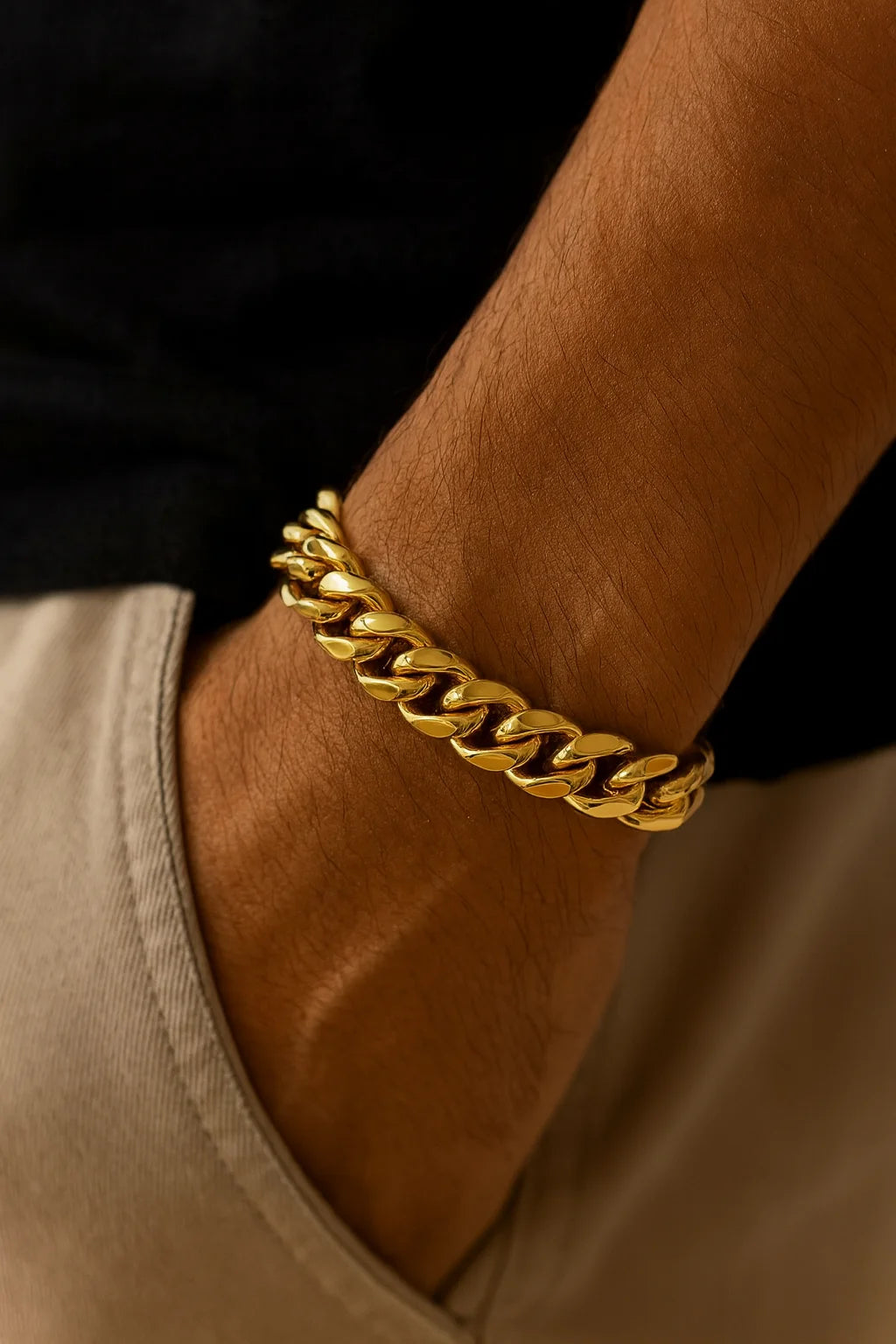 Thick polished gold Cuban link bracelet on man’s wrist for men’s jewelry style