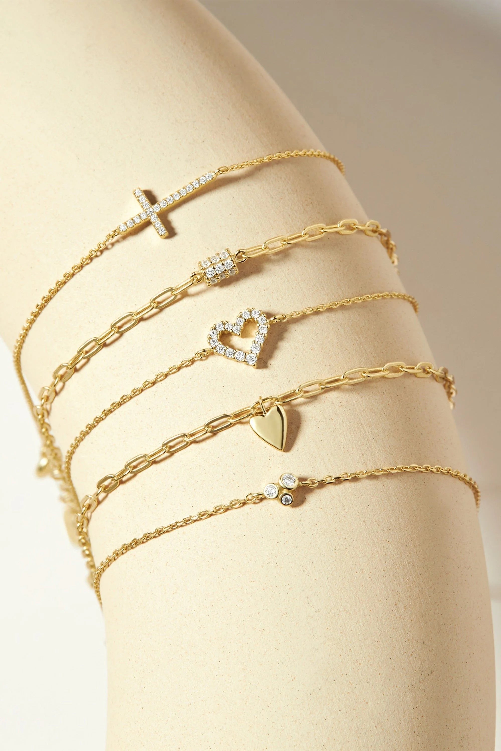 Gold-colored Micro CZ Heart Bracelet with charms including a cross and a heart