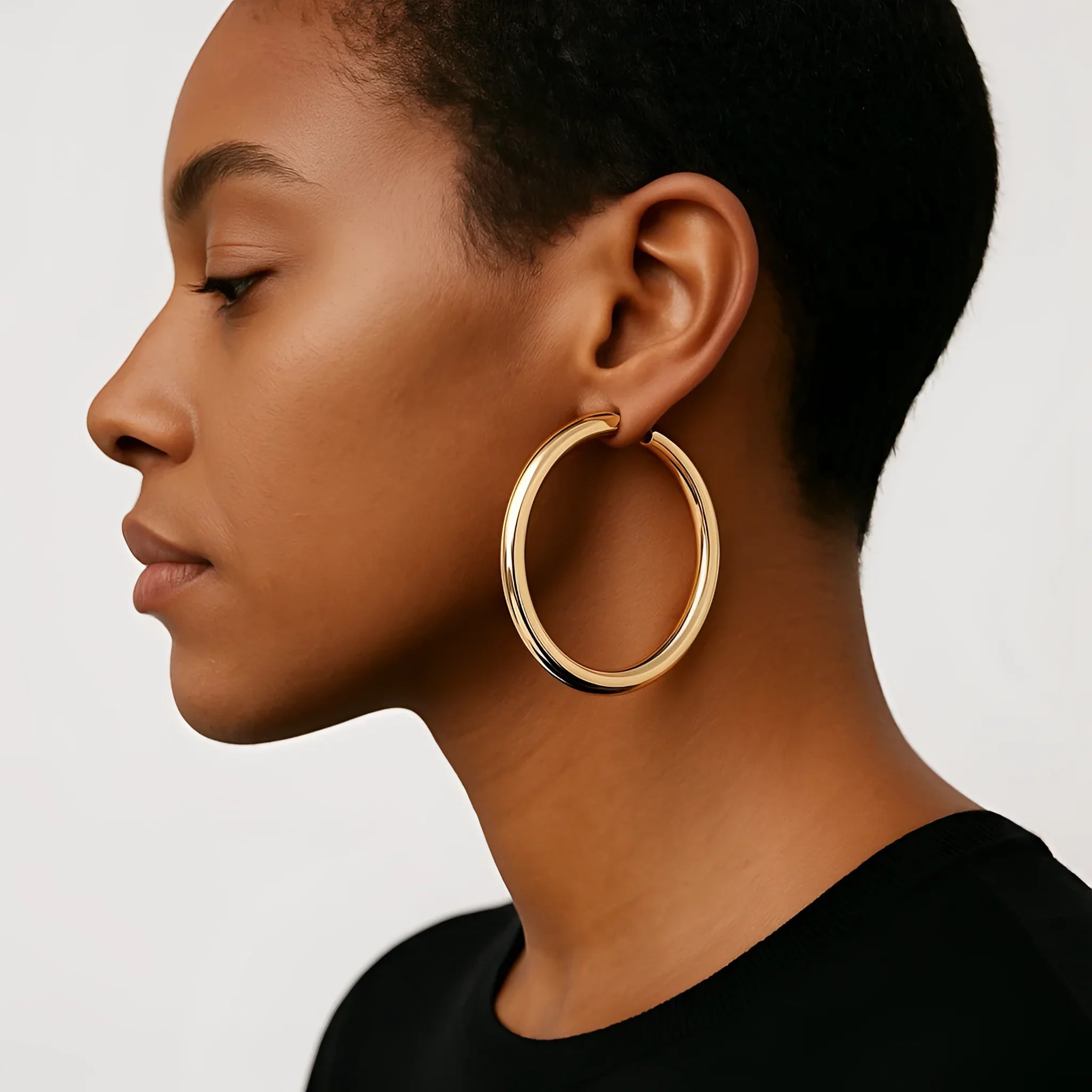 Woman wearing large polished gold Kelly Hoops earring showcasing stylish jewelry