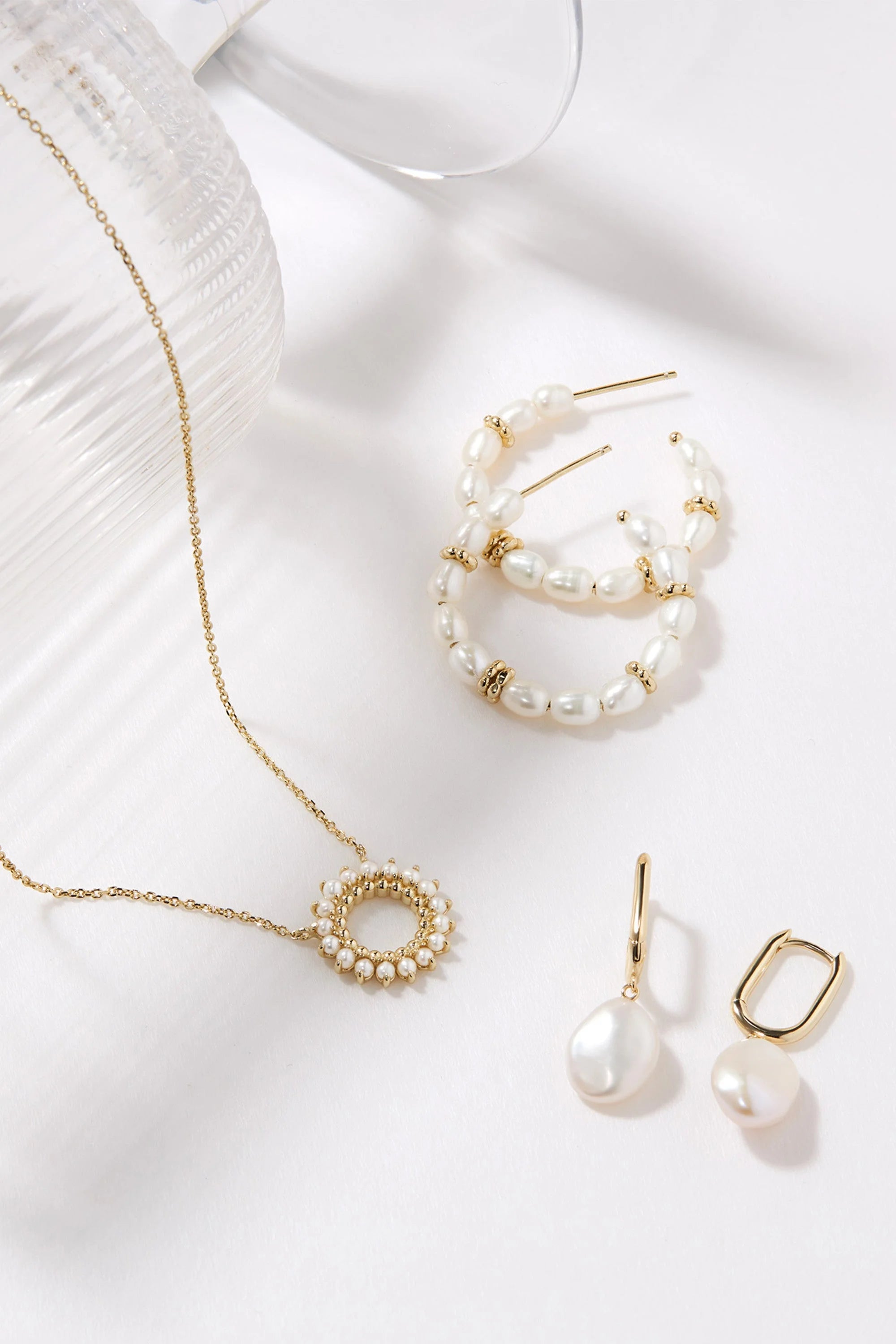 Pearl and gold jewelry set featuring Oval Huggie Hoops with Pearl Drop Earrings