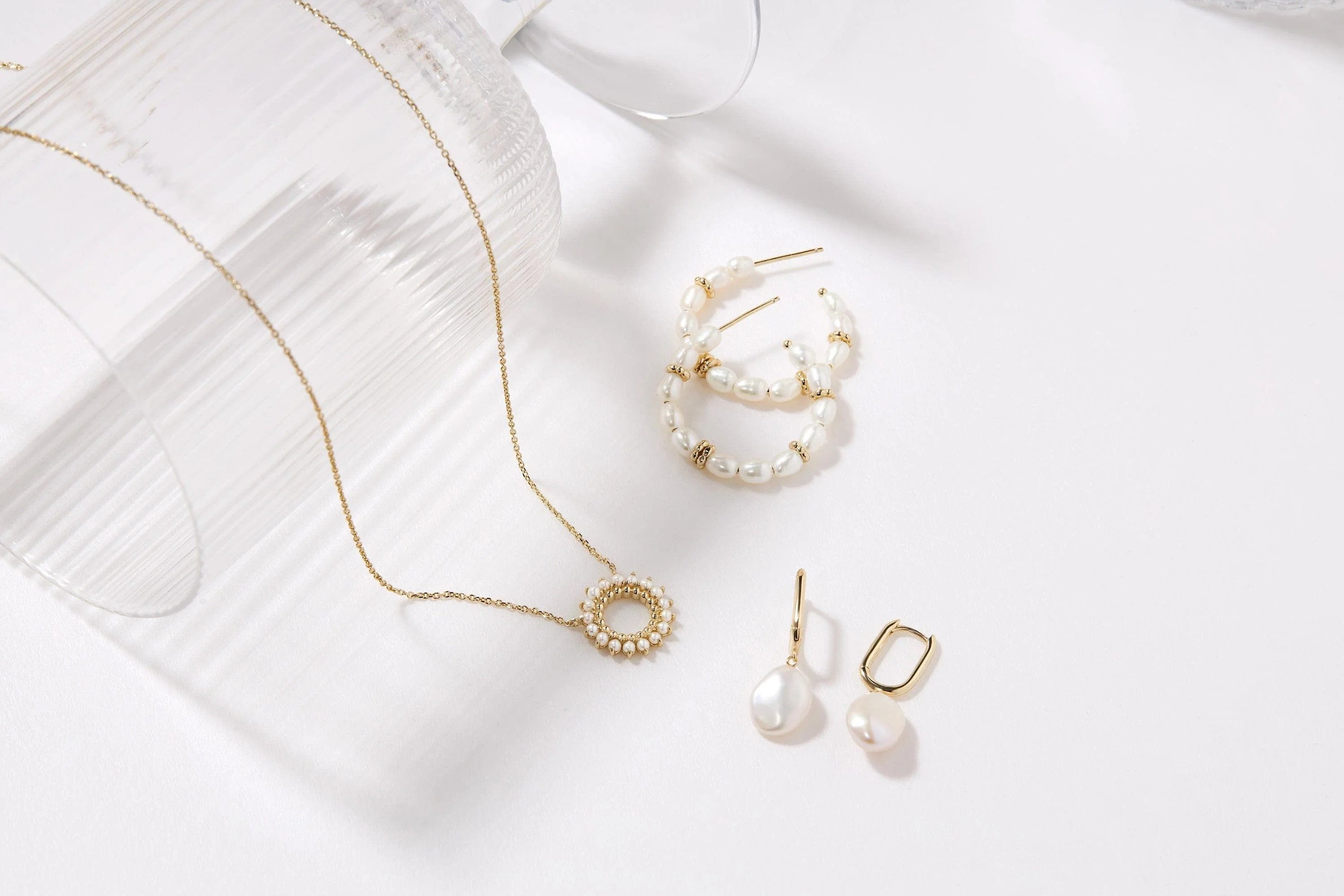 Gold necklace and pearl earrings from Pearl Beaded Huggie Hoops collection