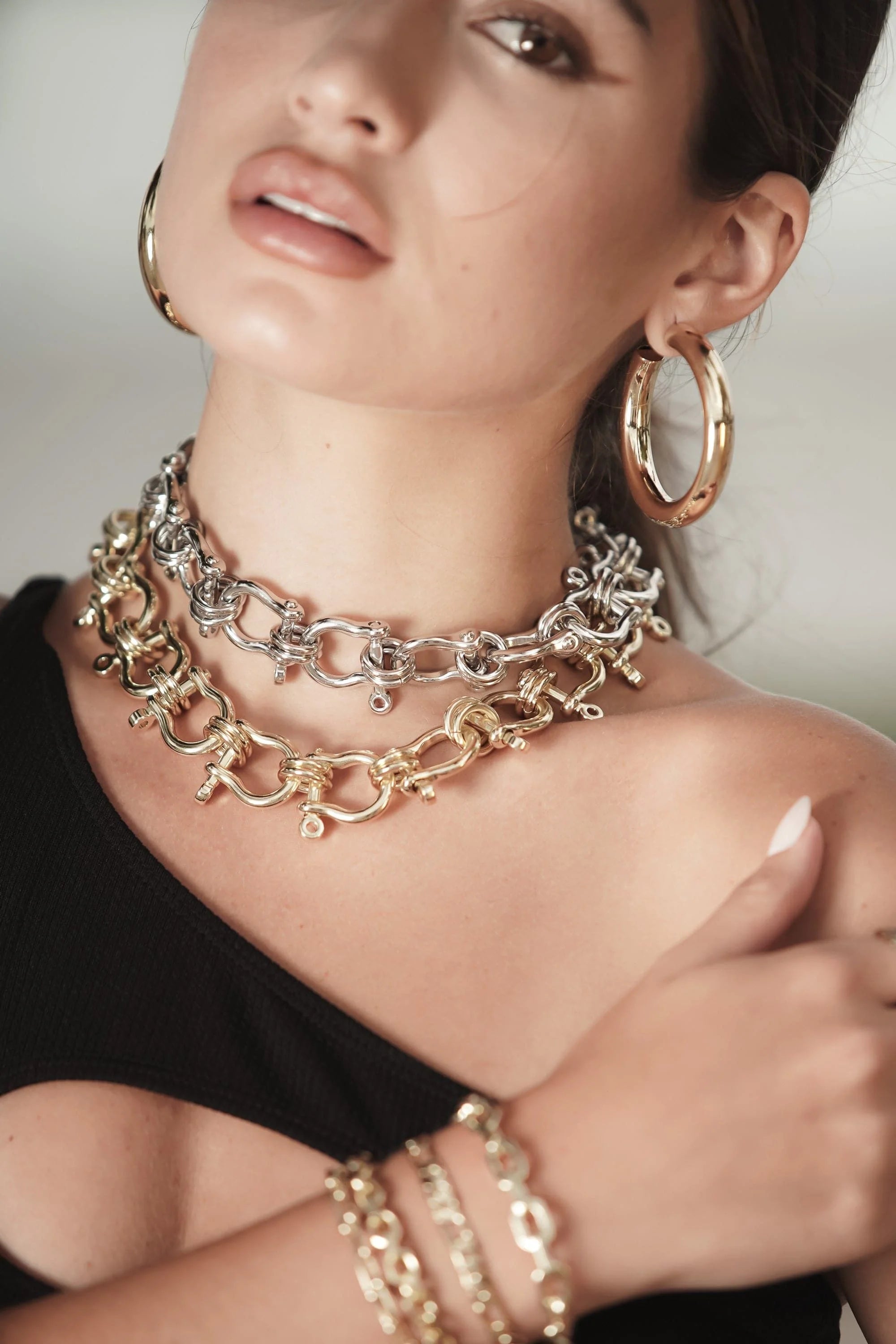 Woman wearing stylish gold and silver jewelry with the Harrison Necklace featured