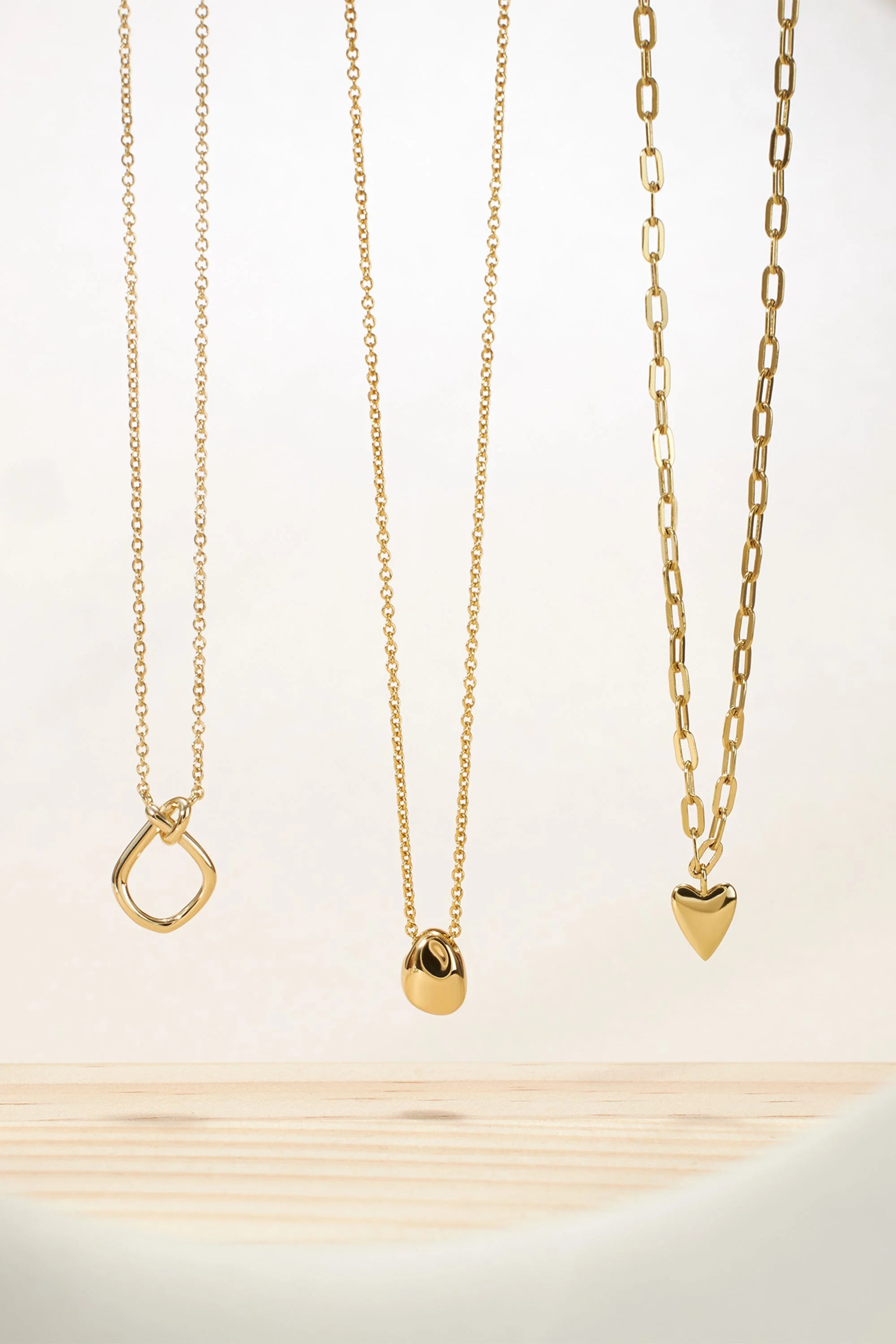 Three gold necklaces from the Micro Harmony Pebble Pendant Necklace collection