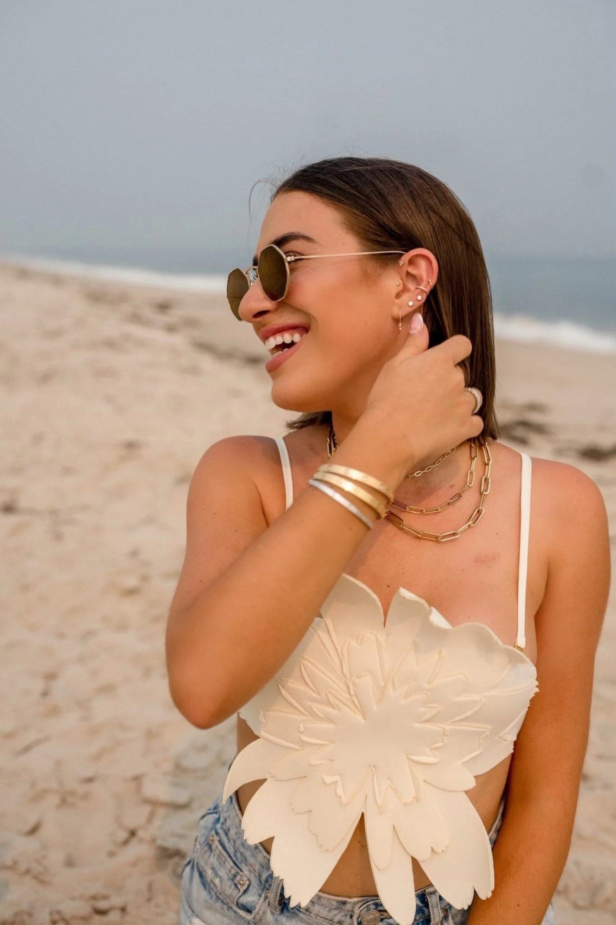 Smiling woman in floral top wearing the Dr Bridget Necklace beautifully