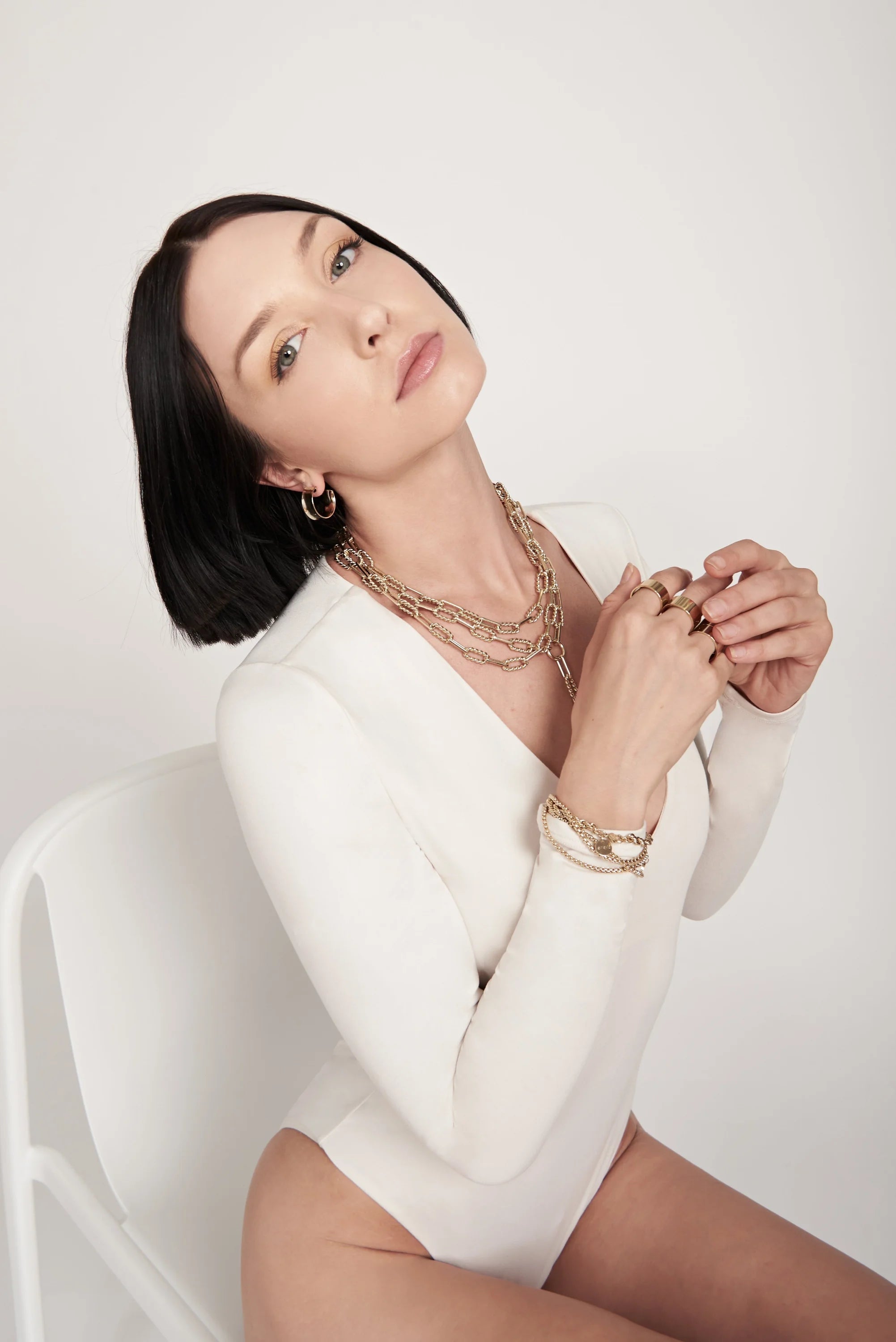 Woman wearing gold jewelry with Enzo Necklace showcasing elegant style