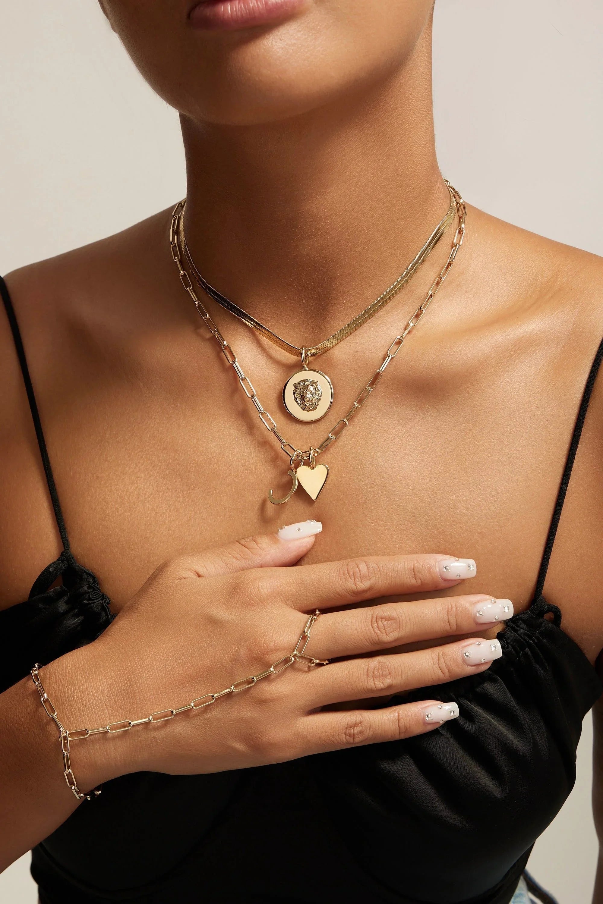 Gold layered necklaces and hand chain for the Melissa Pendant Necklace look