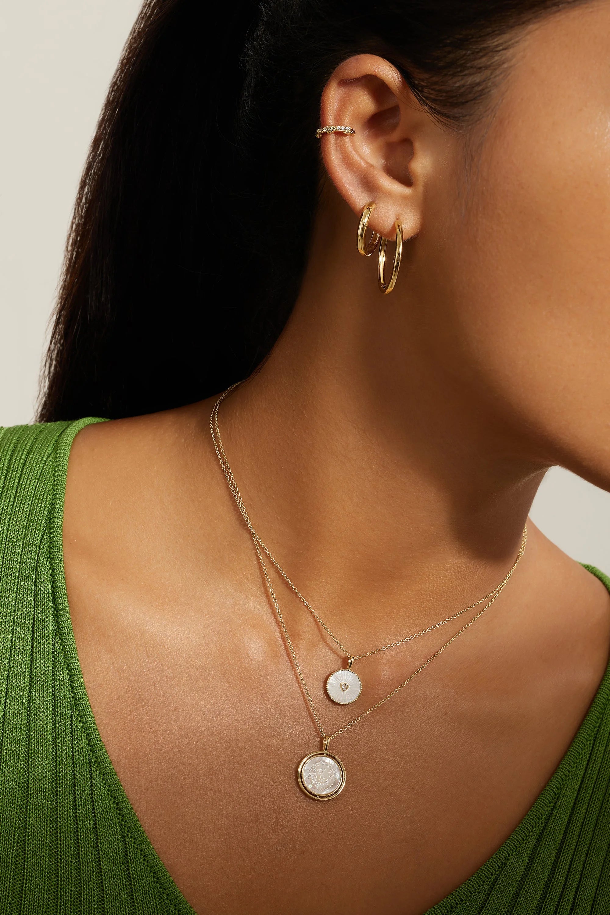 Gold-toned layered necklace with round Mother of Pearl pendants, gold hoop earrings and ear cuff