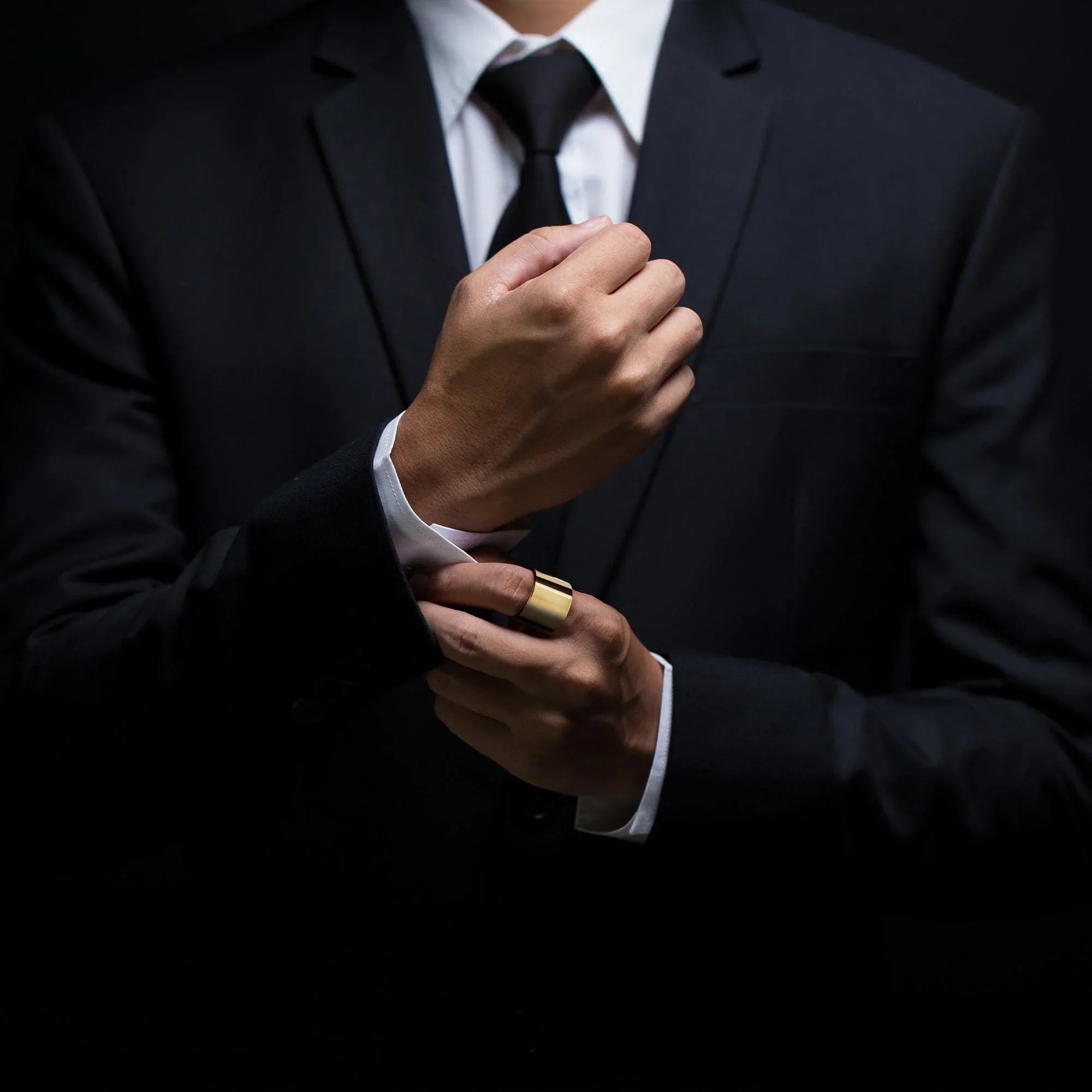 Black suit and gold ring from Men’s Thick Flat Ring collection showing style and elegance