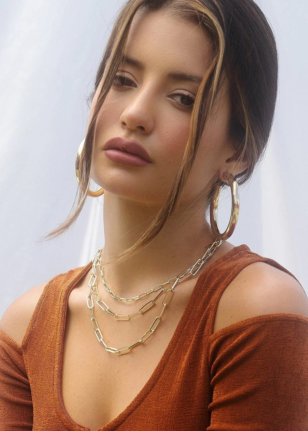 Woman wearing a stunning gold Triple Multi Layer Chain Necklace, perfect for stylish looks