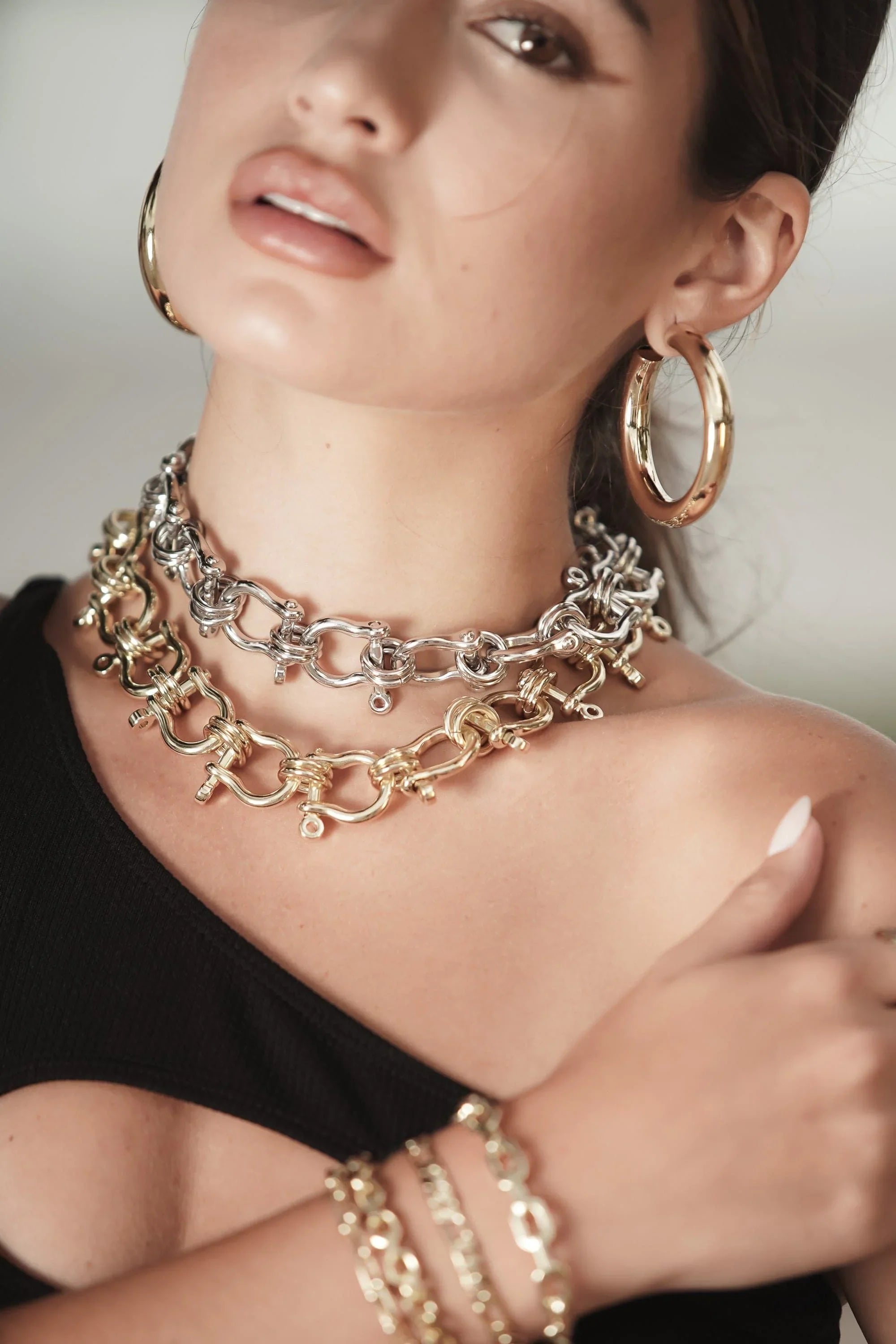 Woman showing off Harrison Necklace with gold and silver jewelry look