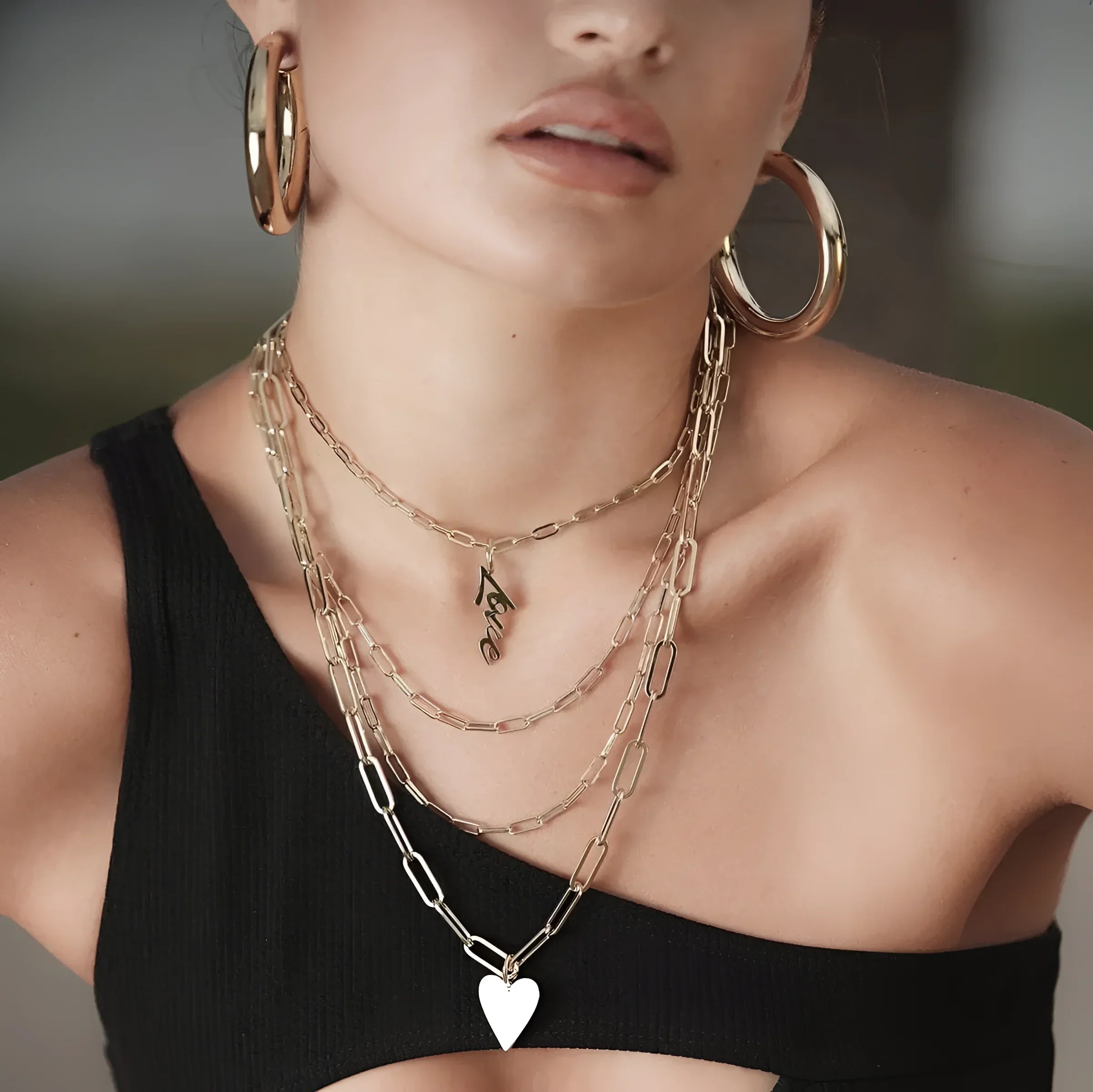 Woman wearing large elongated link chain jewelry made from recycled brass paper clips