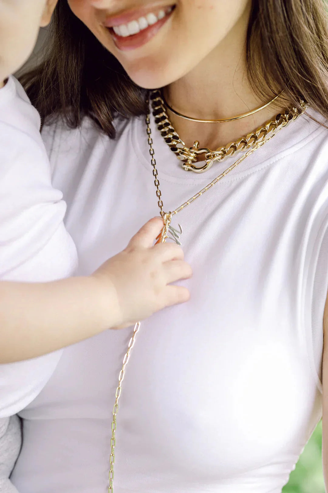 Woman wearing layered medium link chain lariat made from recycled brass plated jewelry