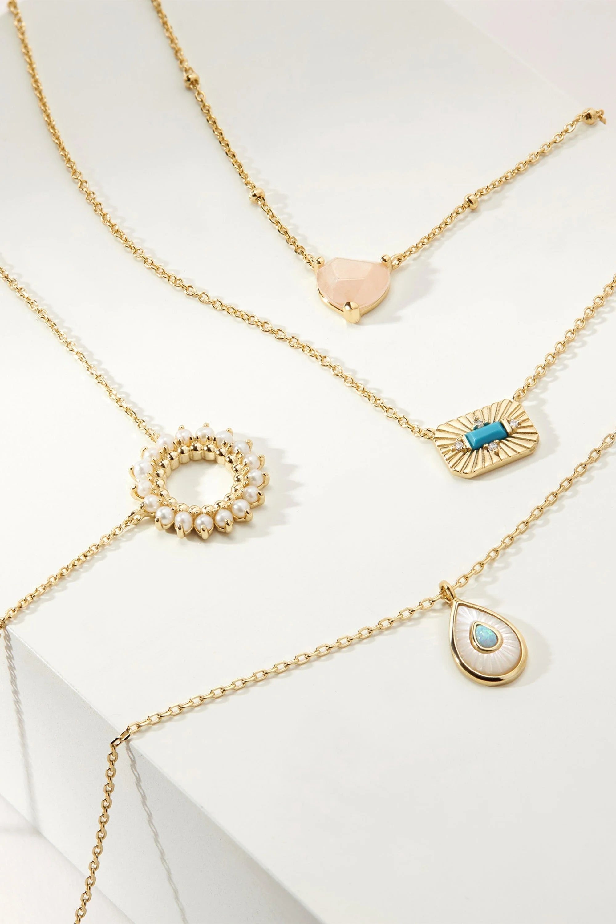 Gold necklaces with various pendants, including the Open Center Multi Pearl Pendant Necklace