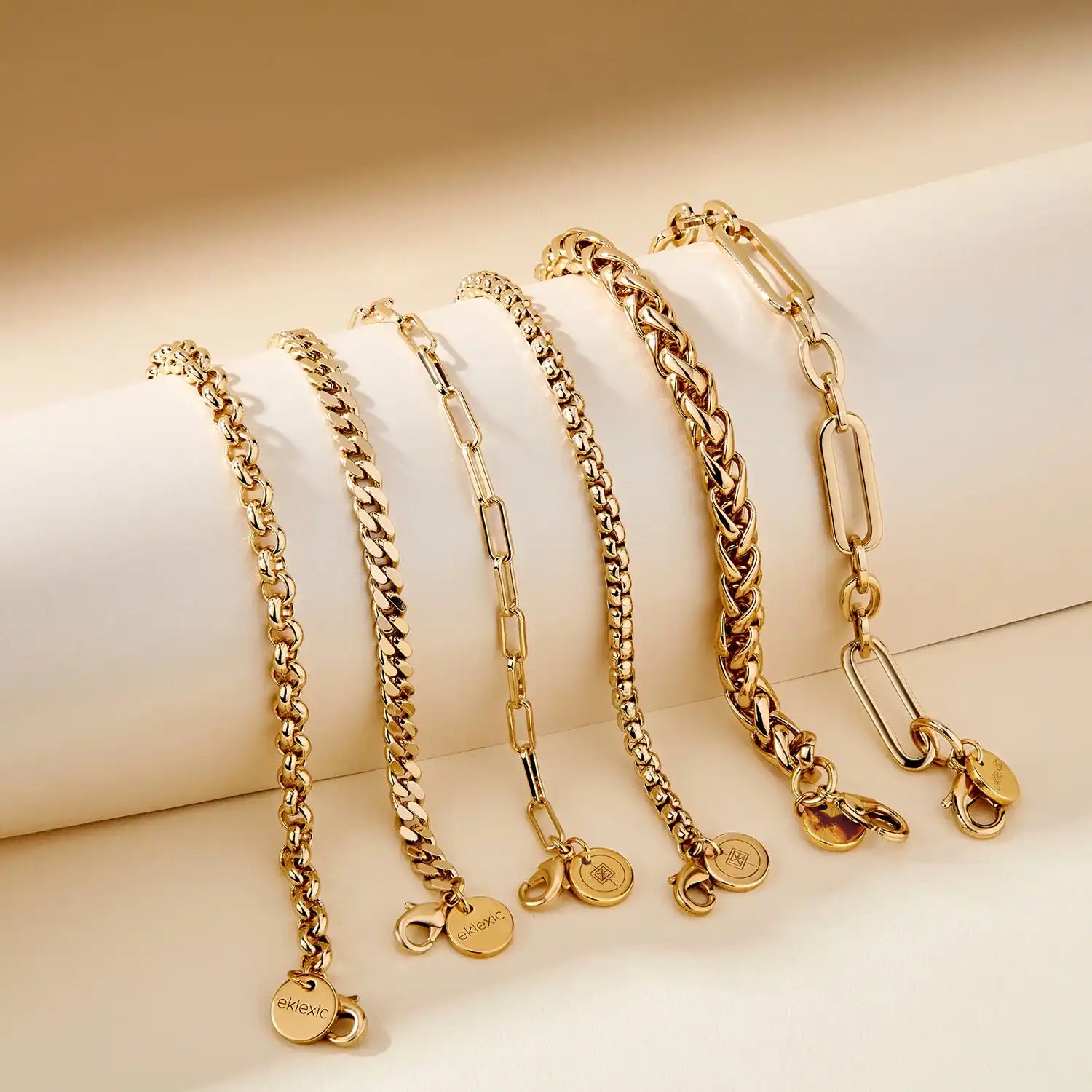 Set of gold chain necklaces on a beige background