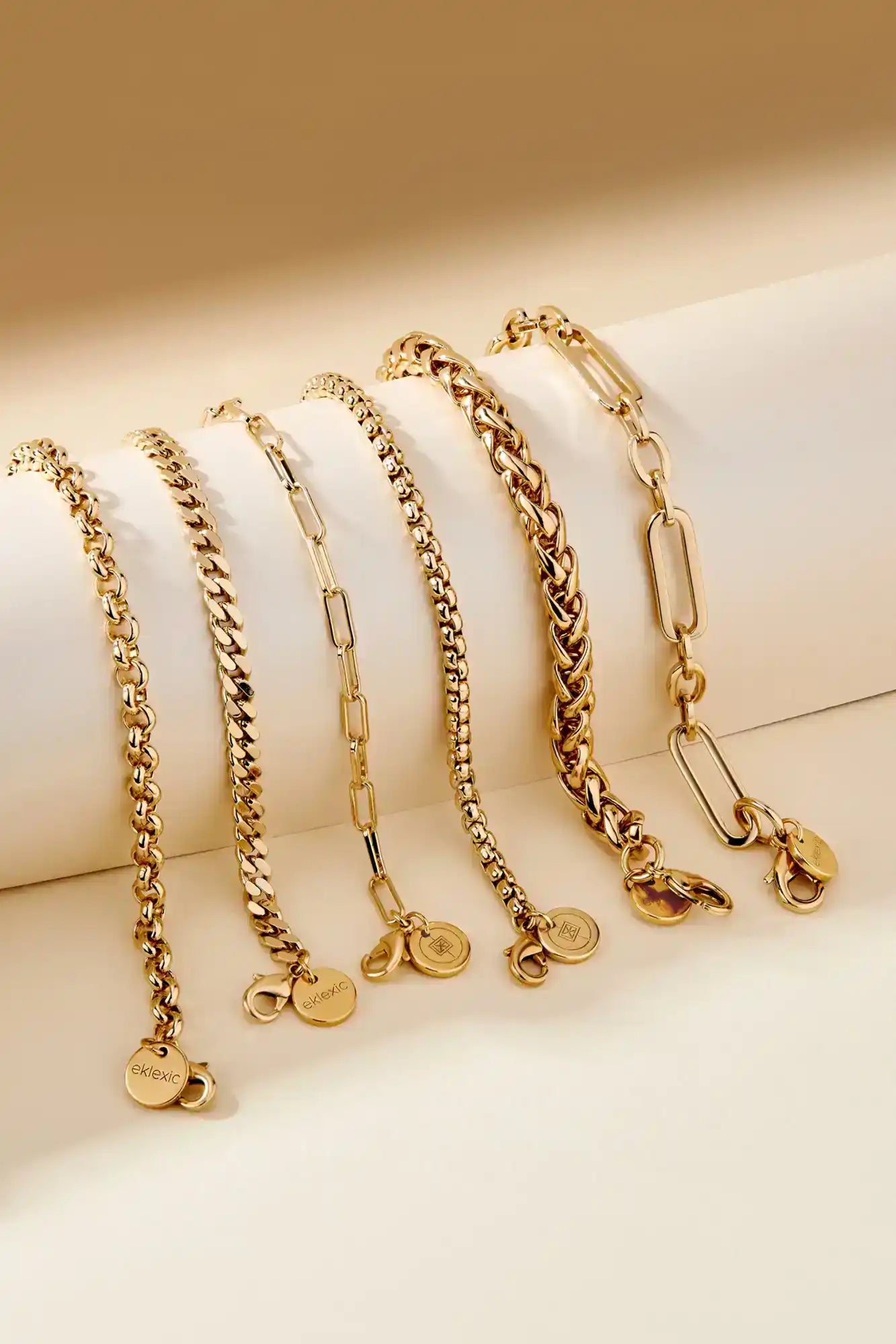 Six golden chain bracelets with charms.