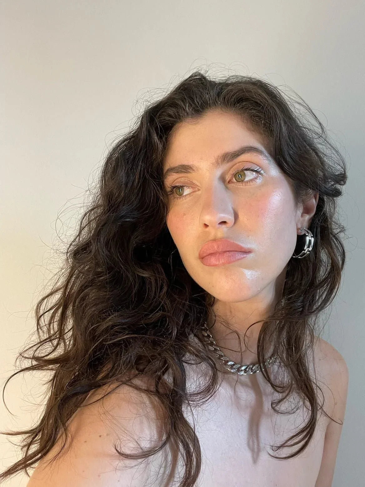Woman with wavy dark hair wearing the stylish Taraji Necklace and silver jewelry