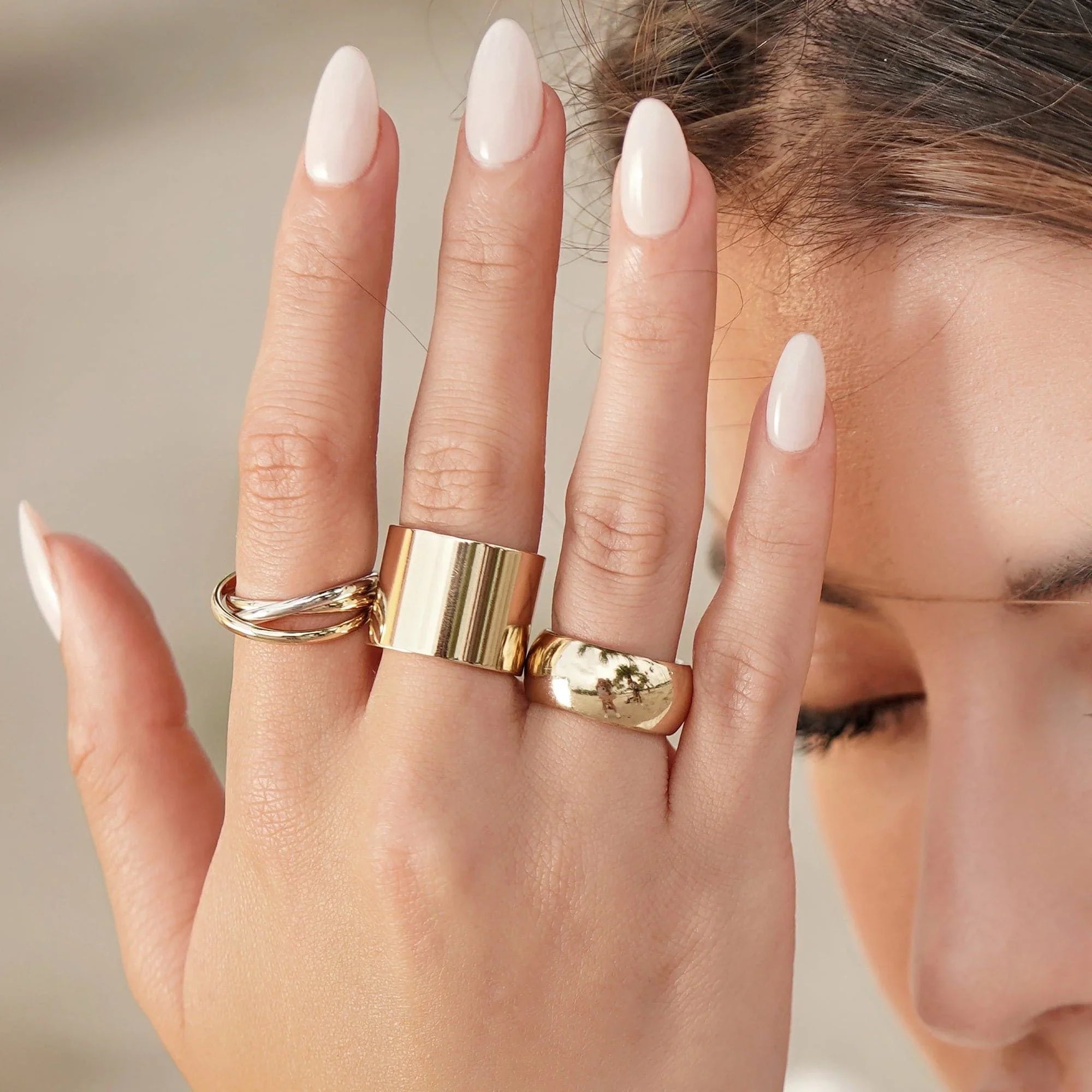 Hand wearing stylish gold rings featuring the Thick Flat Ring product