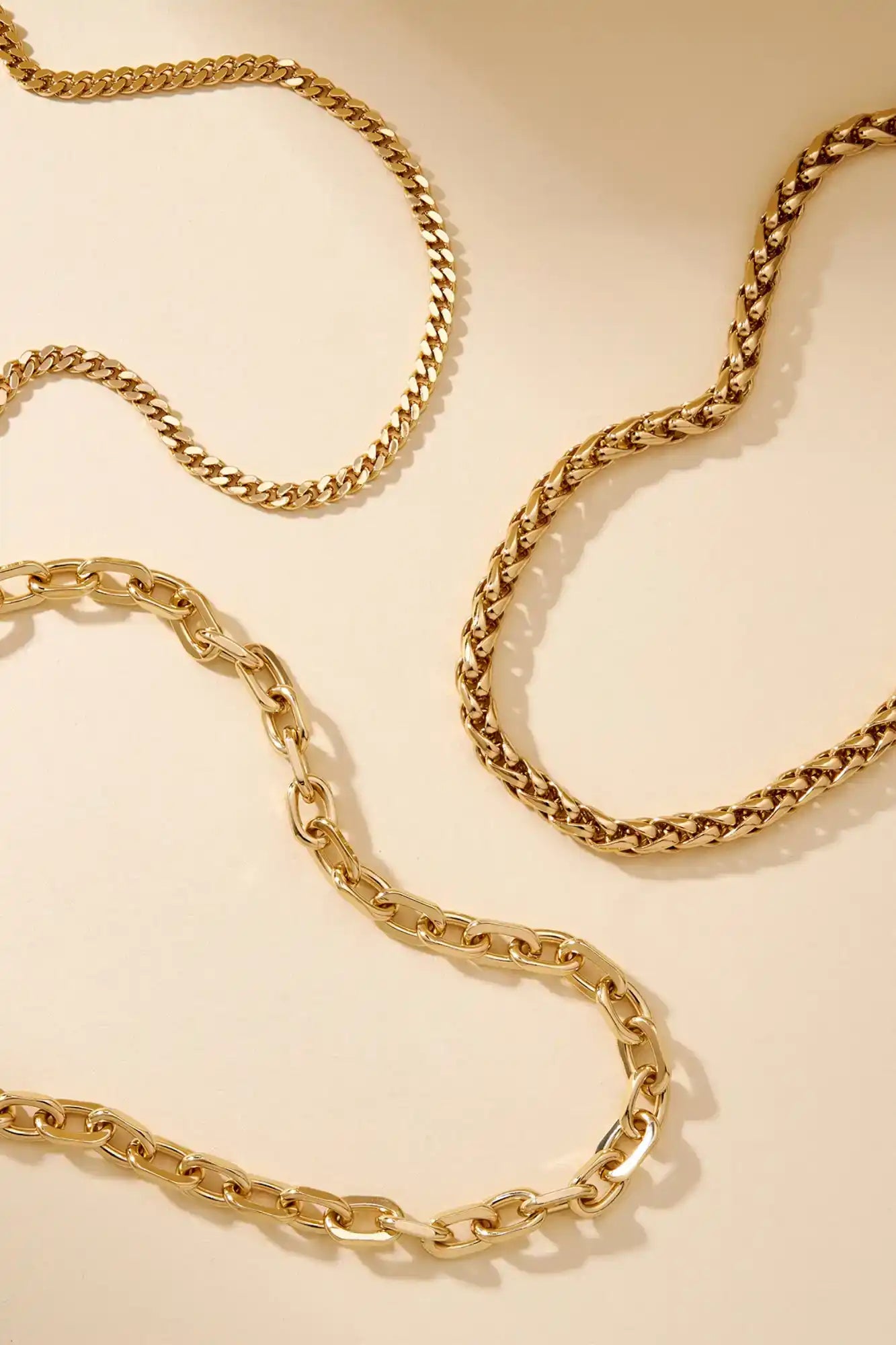 Gold chain necklace on a beige background