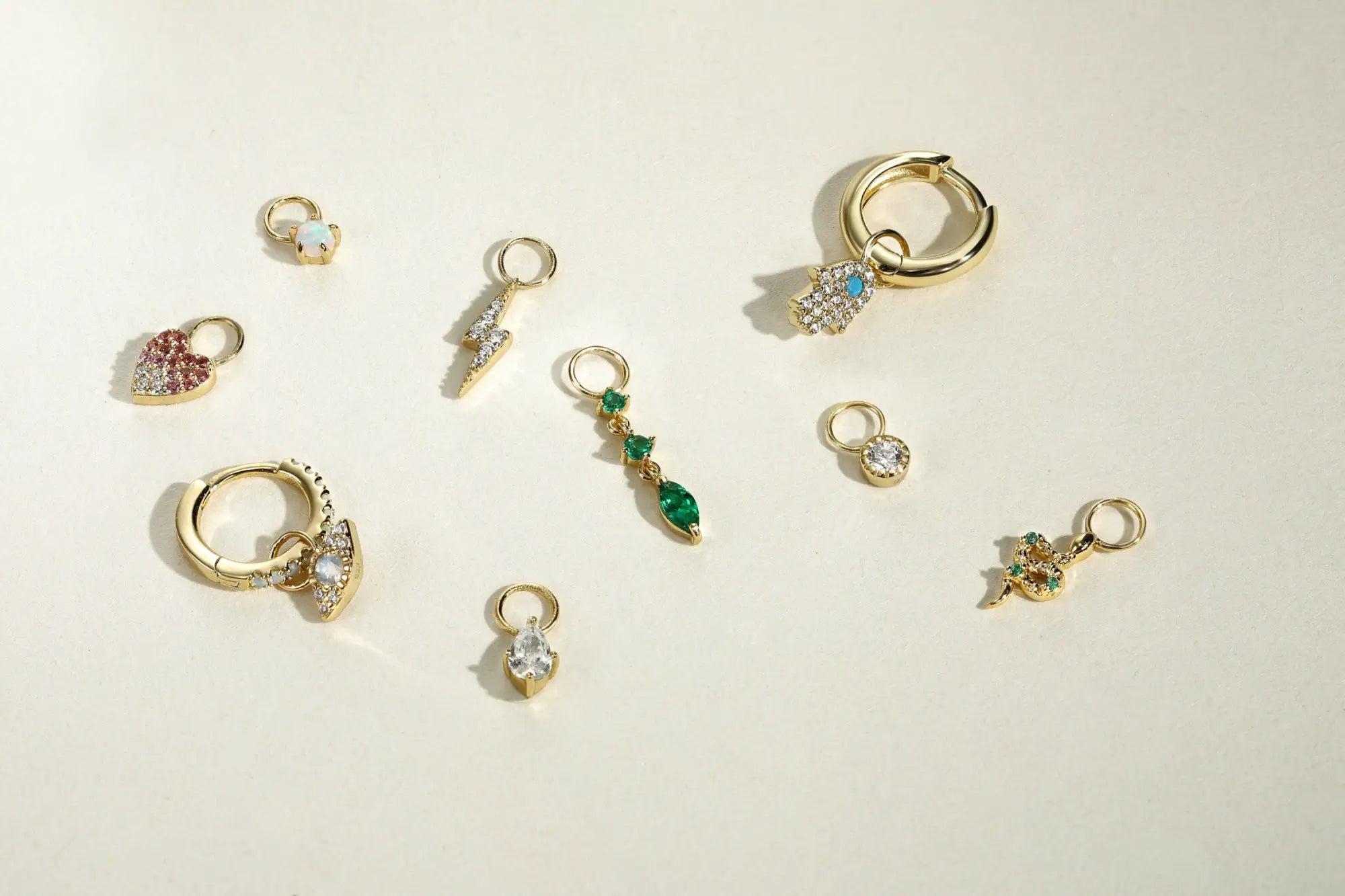 Assorted gold-toned jewelry charms for step-by-step earring customization.