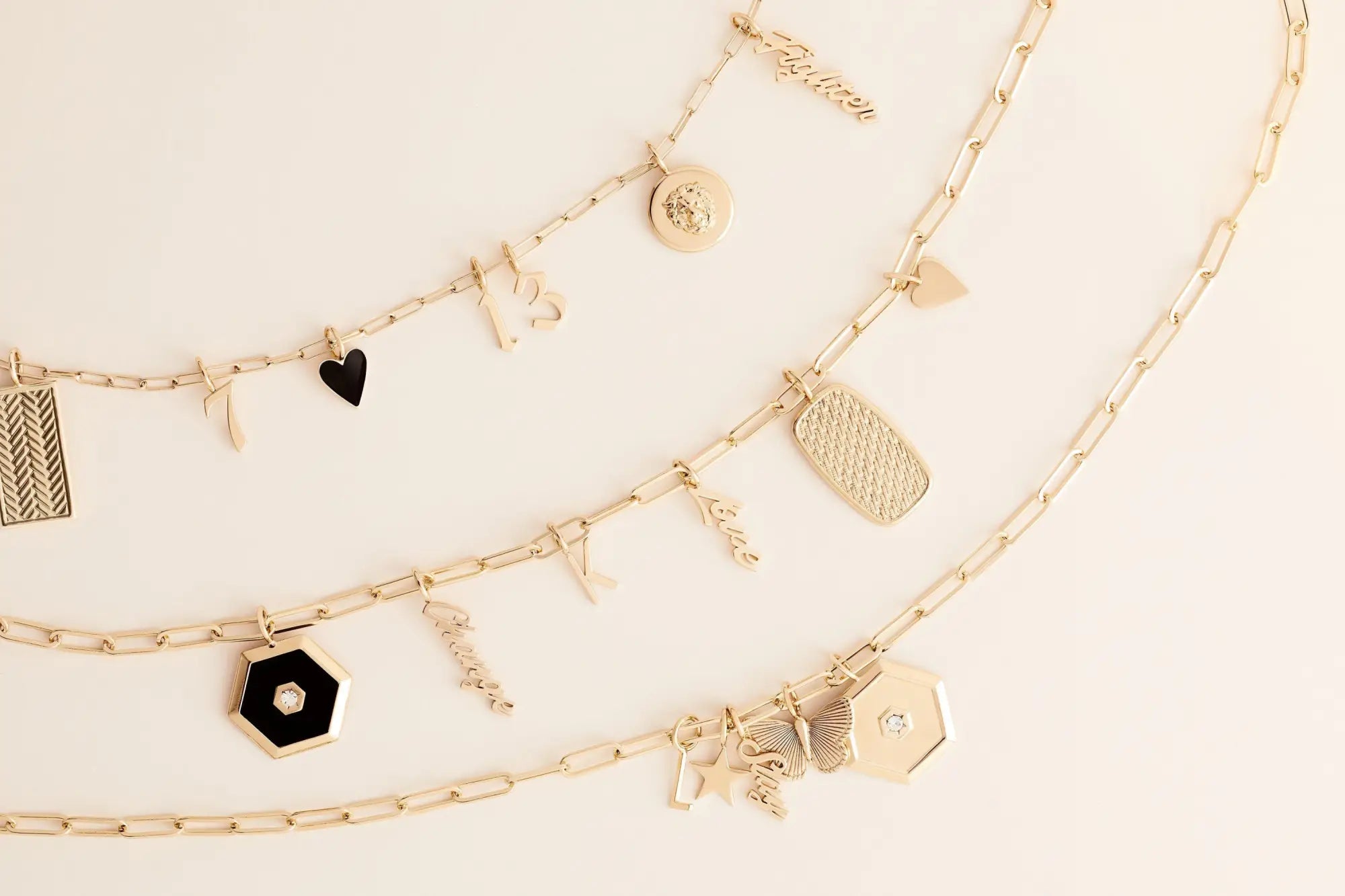 Gold charm necklaces on elongated link chains in a stunning gold color collection.