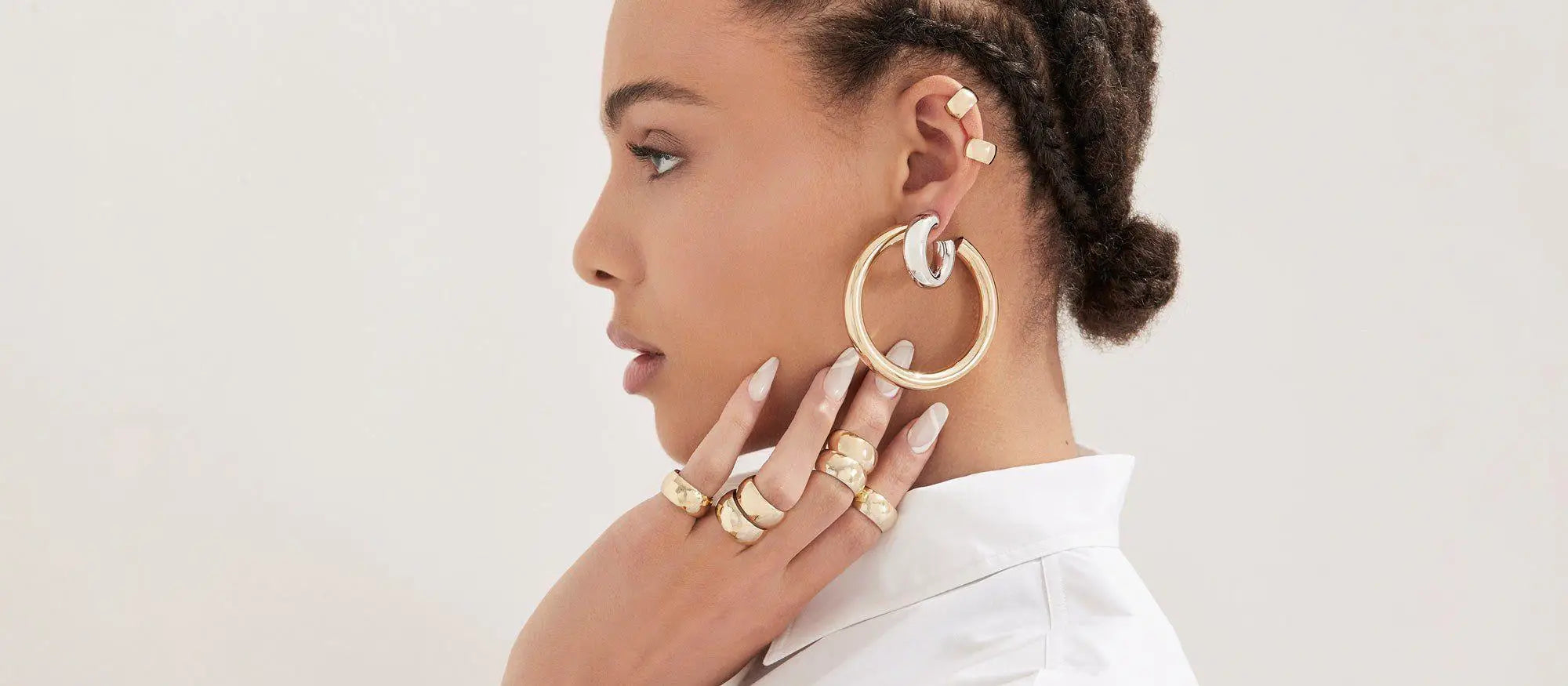 Woman showcasing stunning 14k gold vermeil earrings from an elegant jewelry collection.