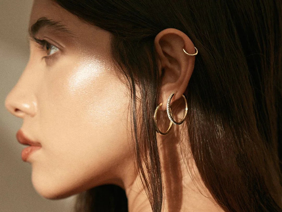 Woman wearing stunning gold jewelry from the Earrings collection