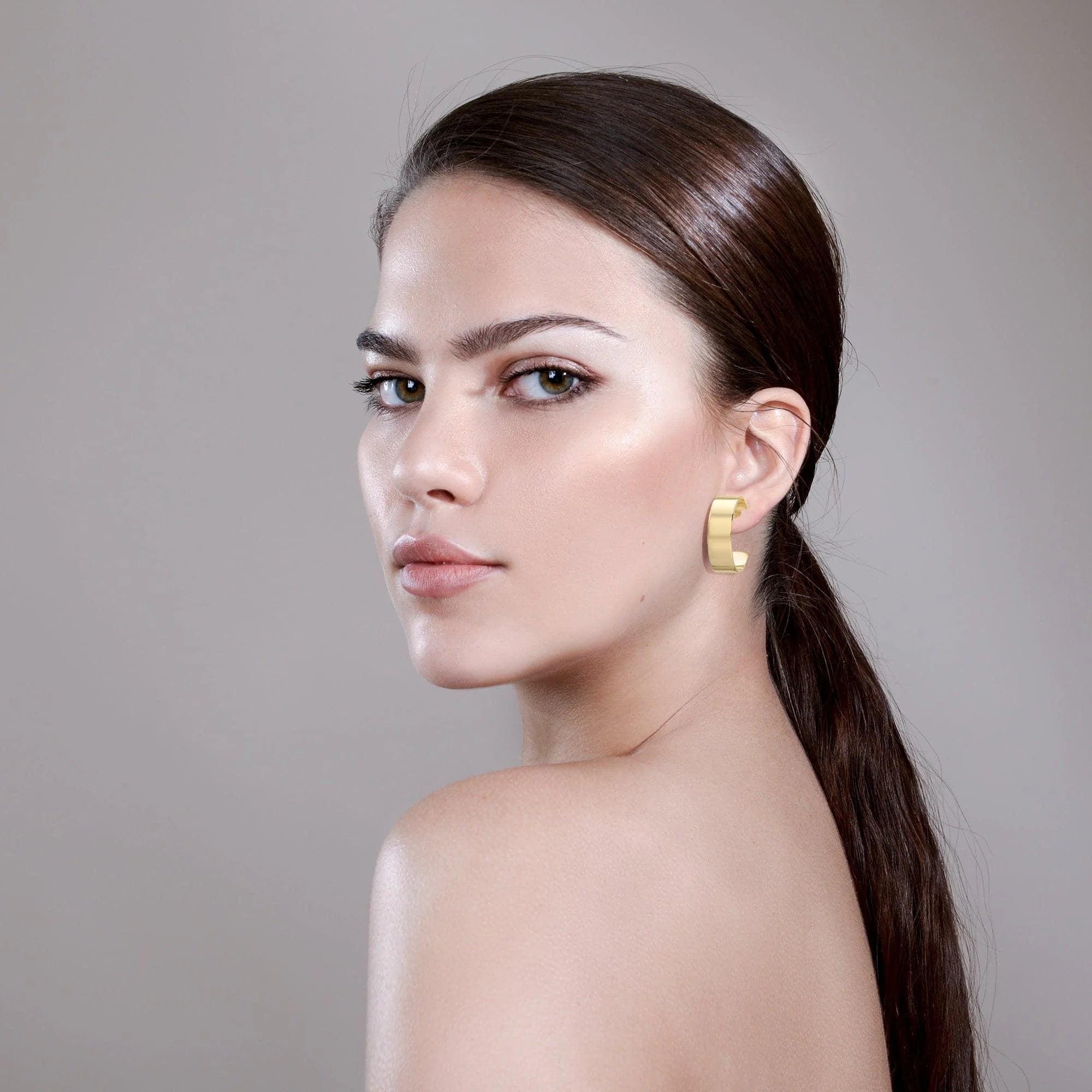 Golden hoop earring from Skylar Hoops collection in wide flat brass with 14k gold rhodium finish