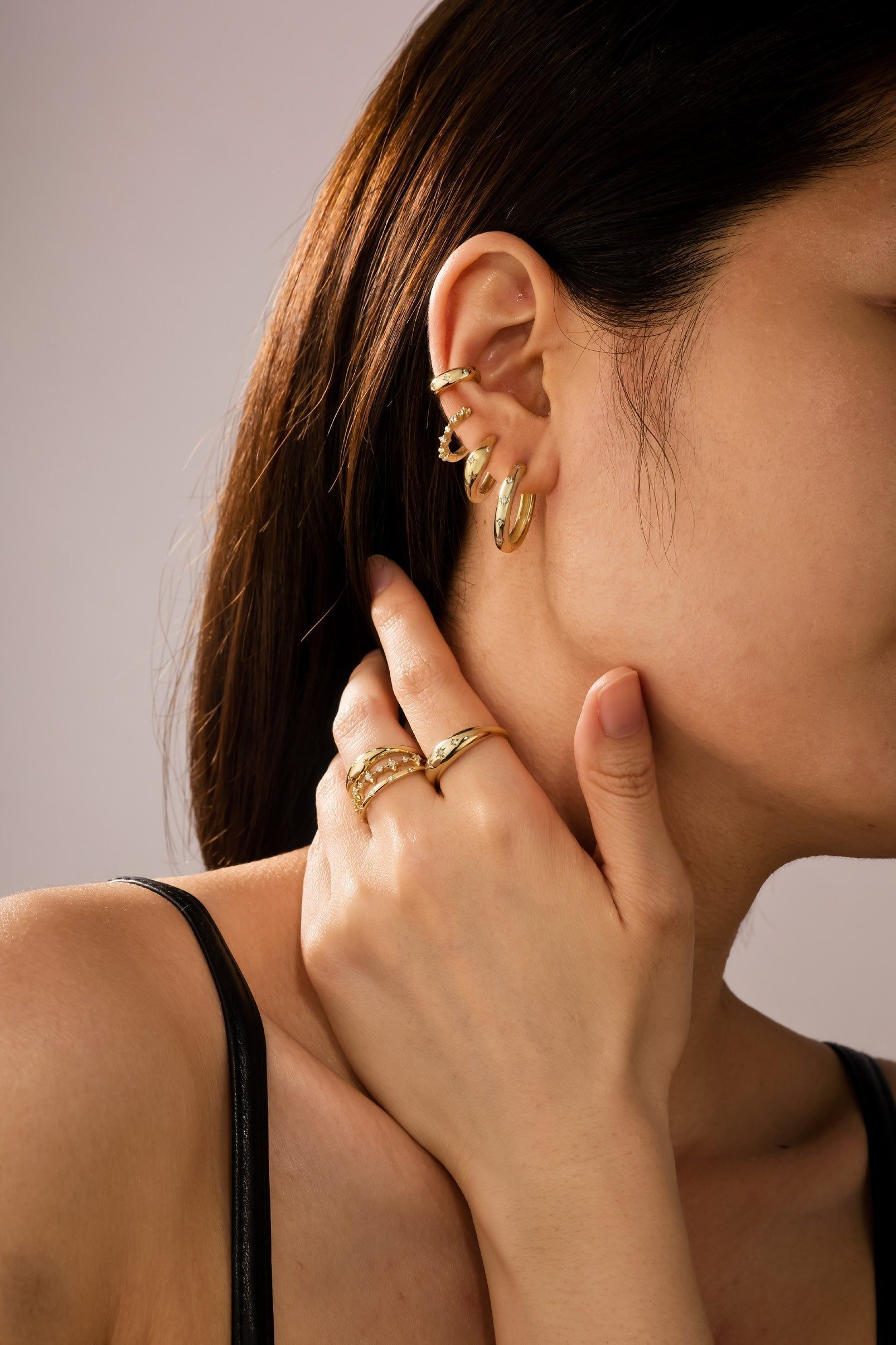 a woman wearing a pair of gold rings