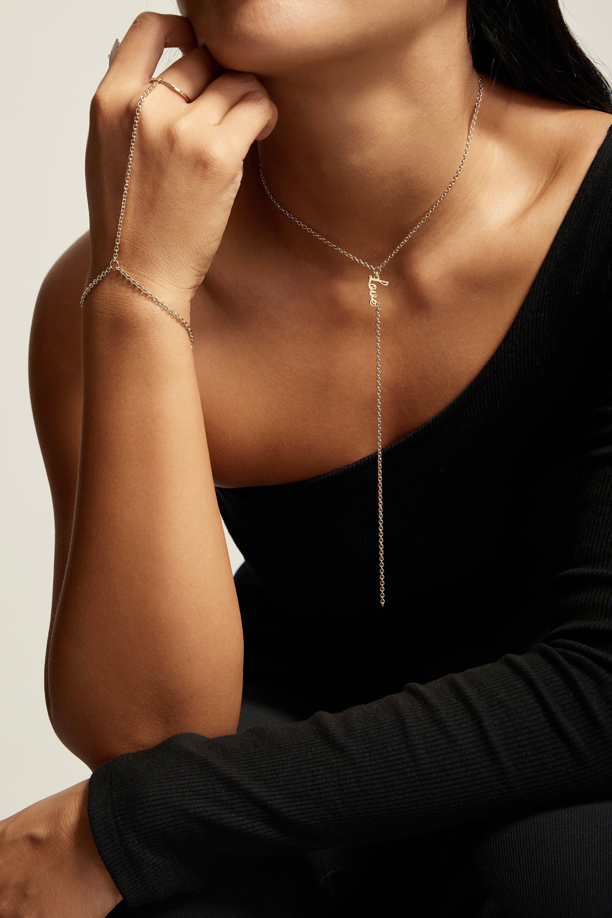 Woman wearing Law Hand Chain in recycled brass with a sleek Rhodium Plating finish, showcasing sophistication and elegance.