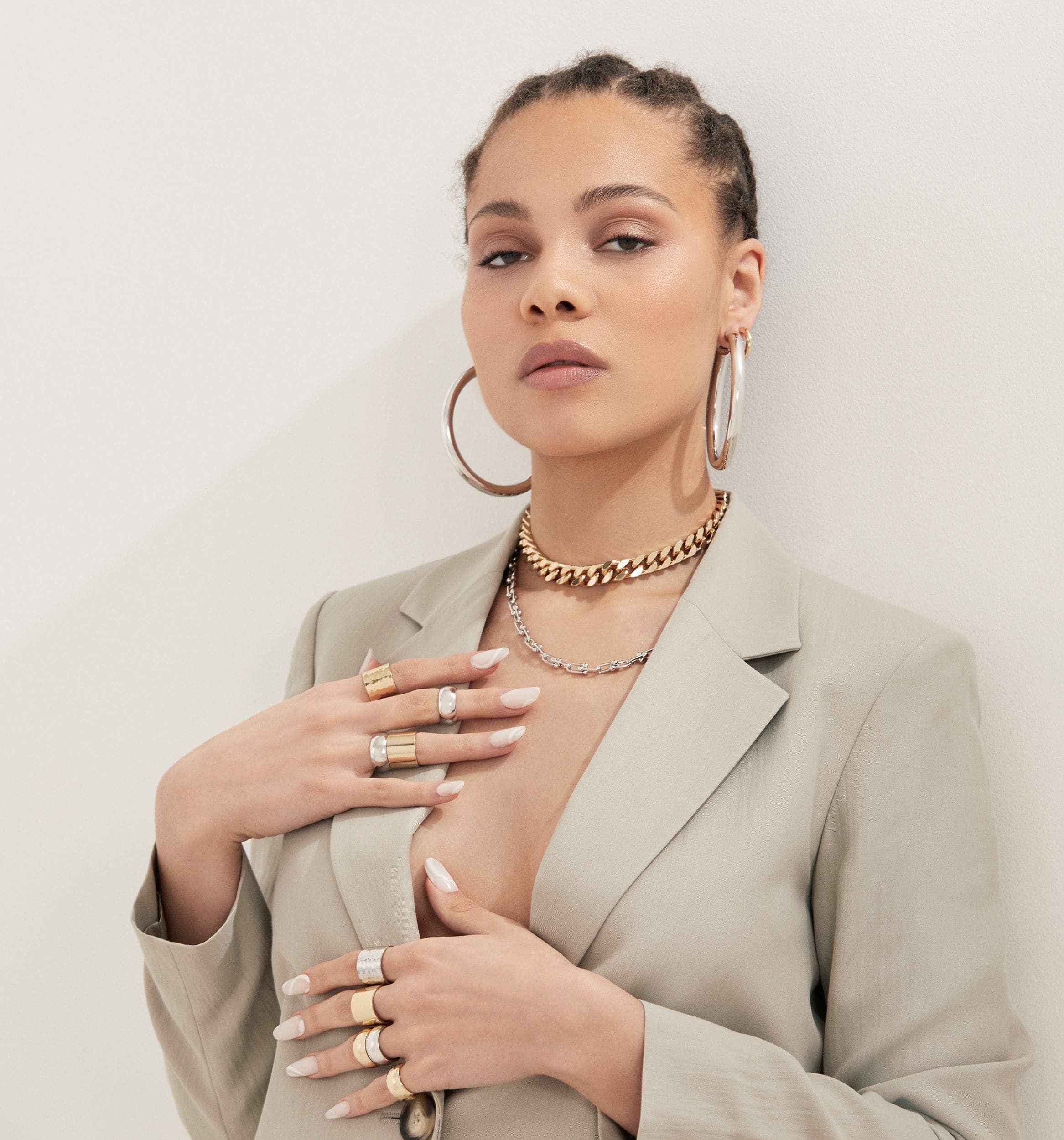 Woman in blazer showcasing Ryan Hoops jewelry for a stylish look