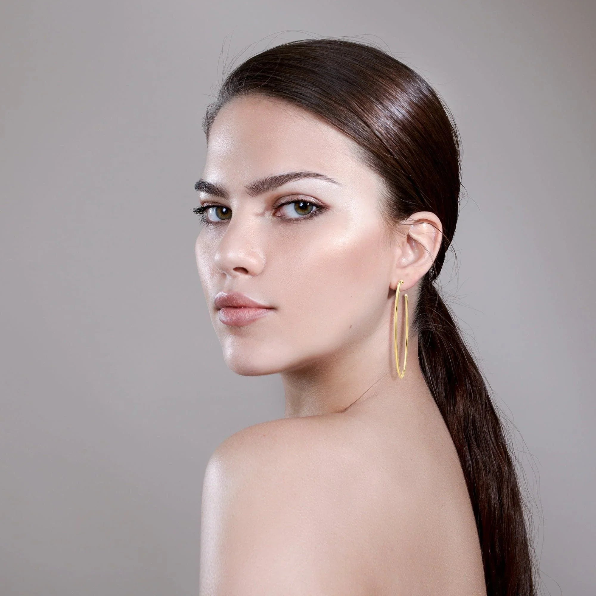 Woman wearing stylish 3 inch gold hoop earrings from 3 Ultimate Hoops collection