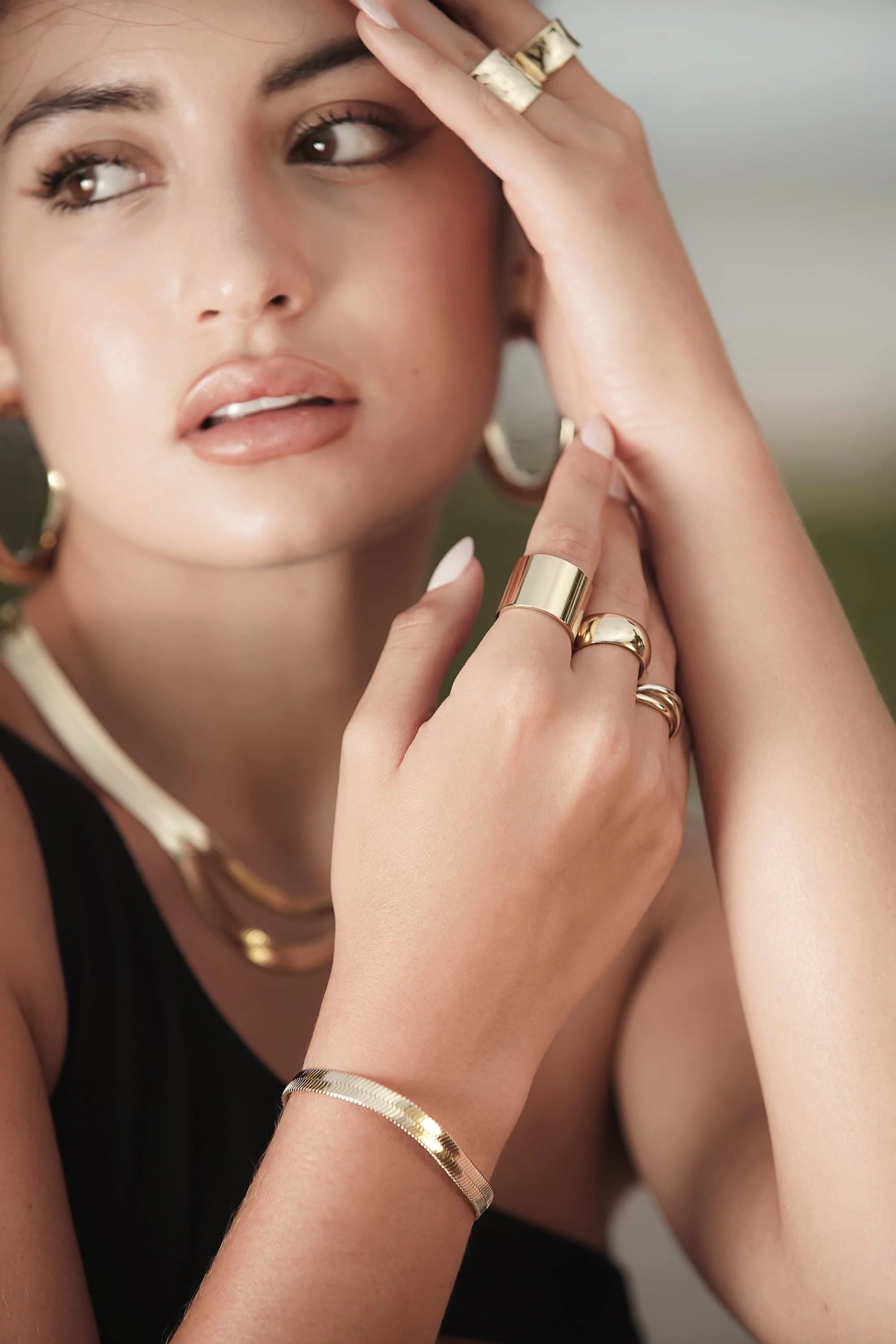 Woman showcasing a stylish 5mm Viper Chain Bracelet with gold jewelry