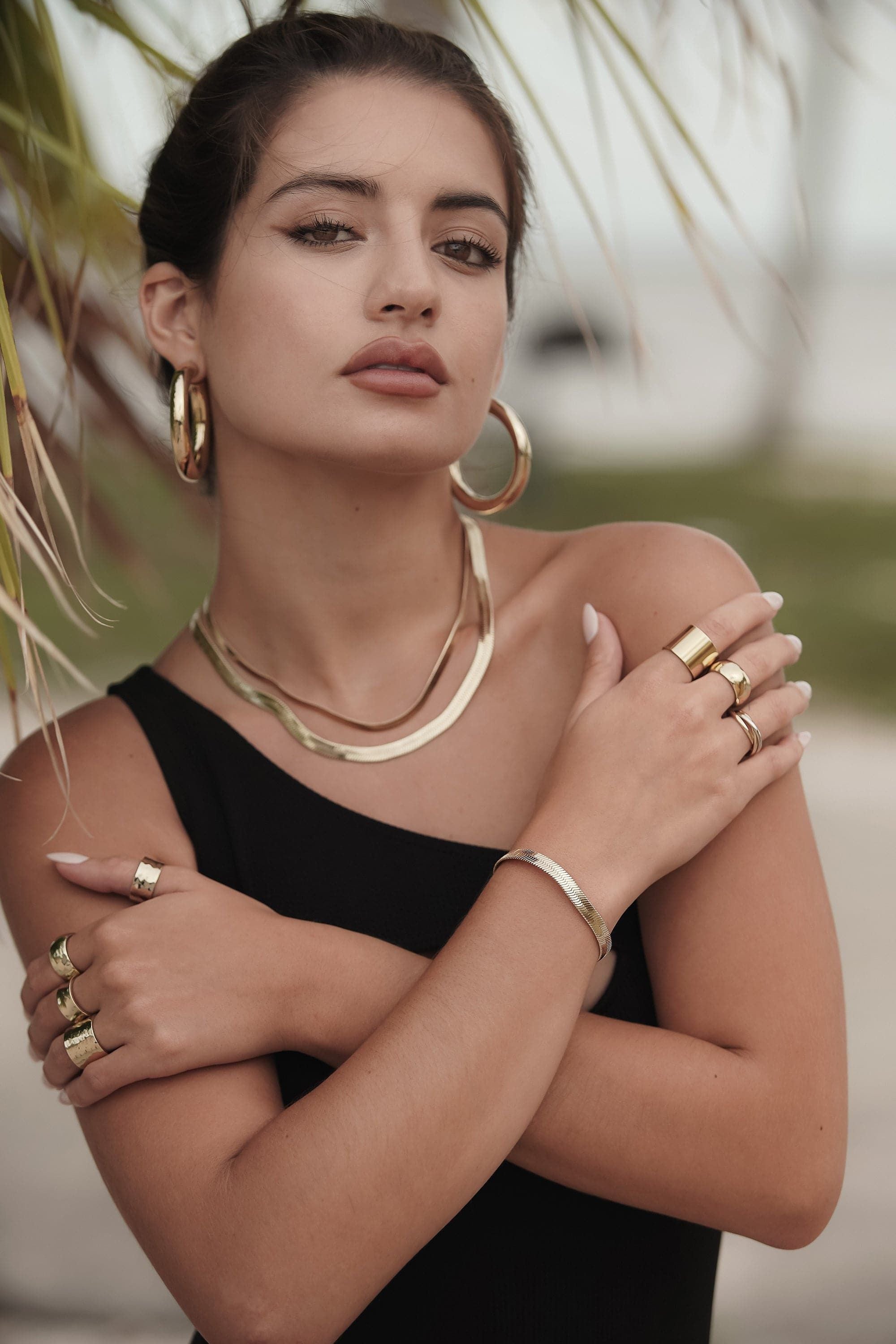 Woman showcasing the 5mm Viper Chain Bracelet made of recycled brass herringbone